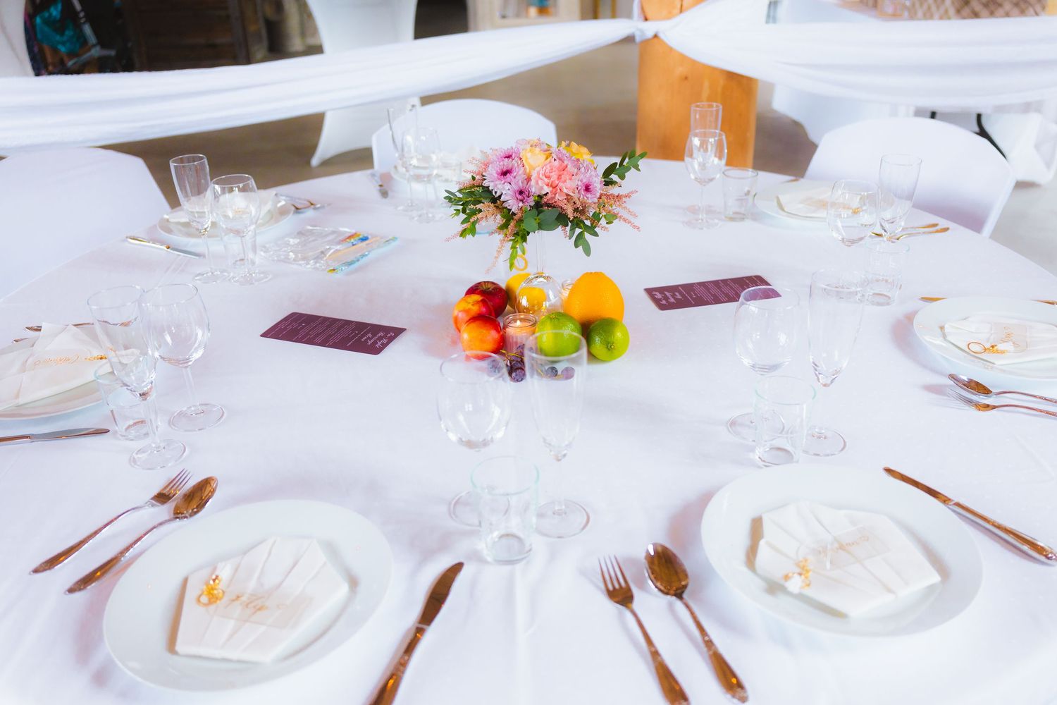 Elegant white tablescapes with floral centerpieces and place settings at a formal event.
