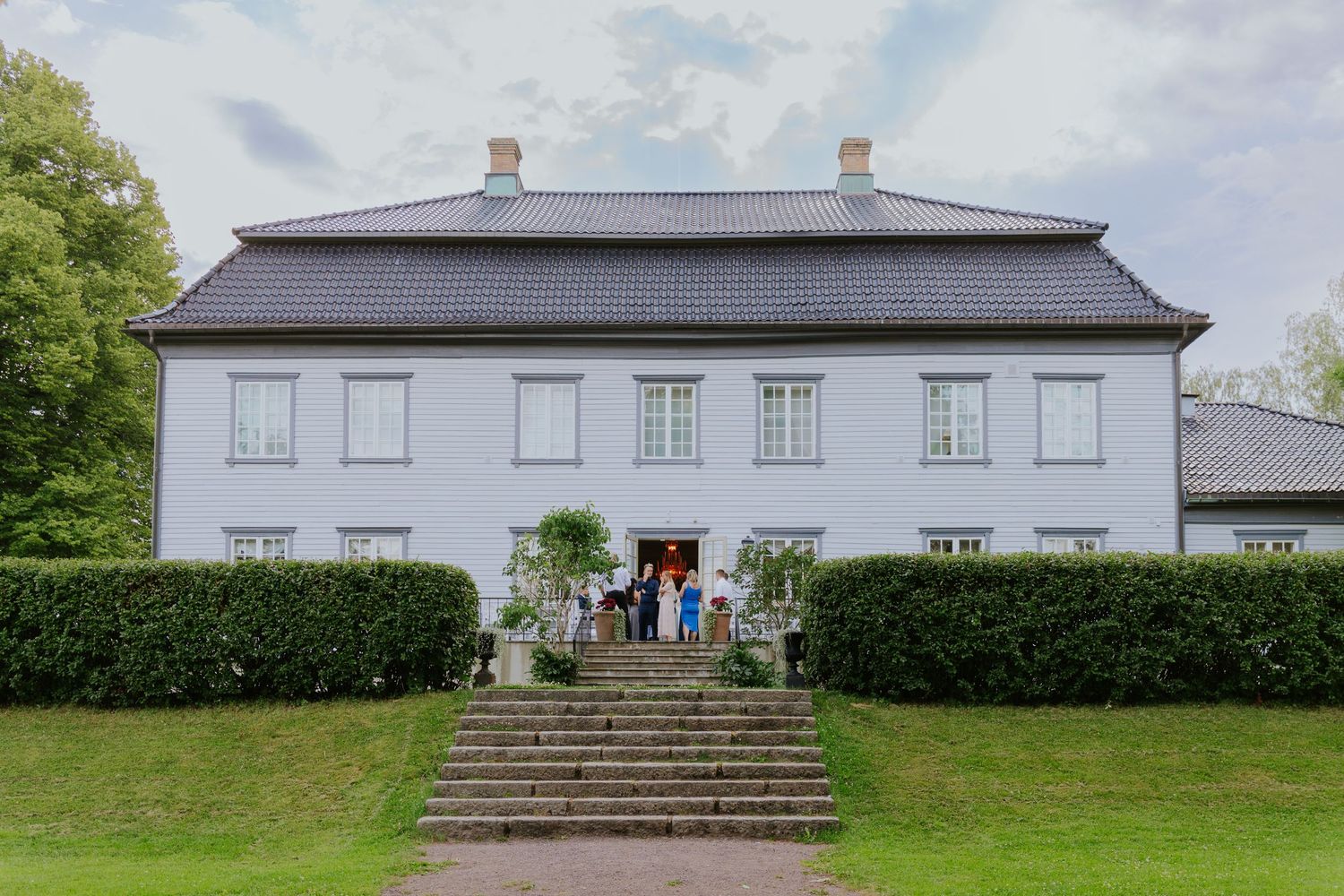 A series of white manor houses with traditional architecture photographed from different angles against green landscapes.