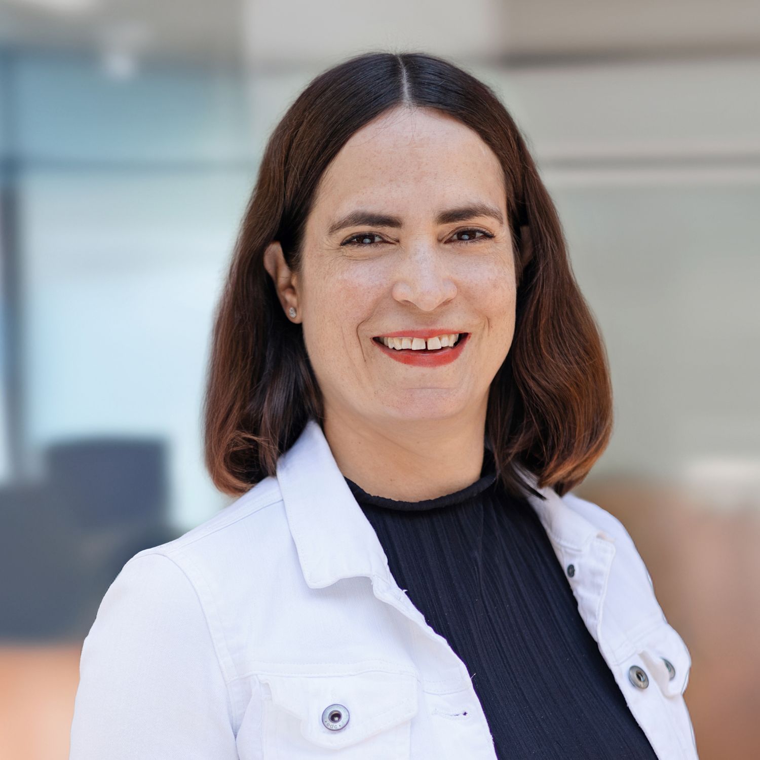 Professional headshot series showing different expressions against a light background in a modern office setting.