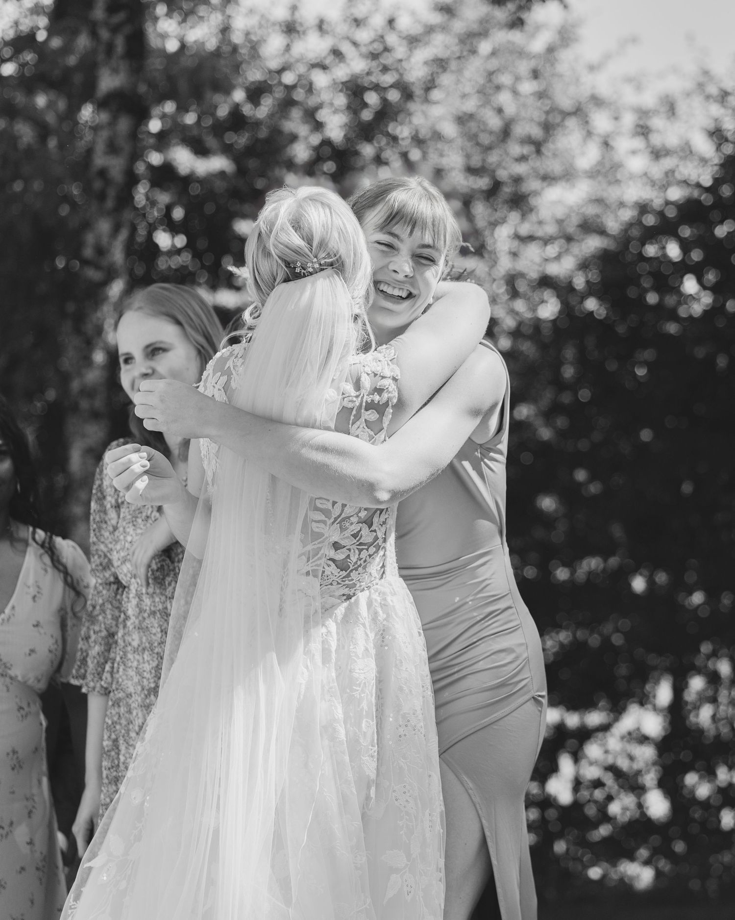 A joyful moment captured in black and white as two people share an emotional embrace outdoors.