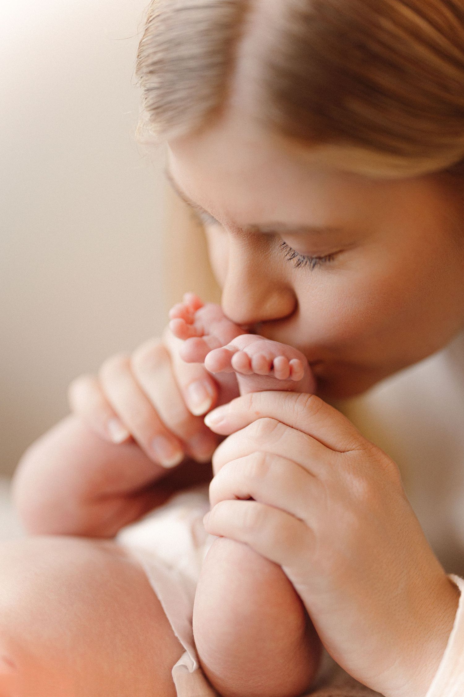A tender moment captured in a series of photos showing a parent gently kissing a baby's tiny feet.