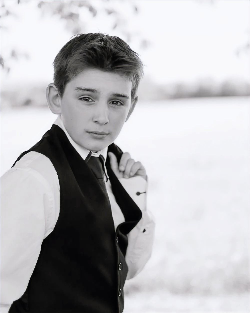 Black and white portrait series of a young person in formal attire against a light background.