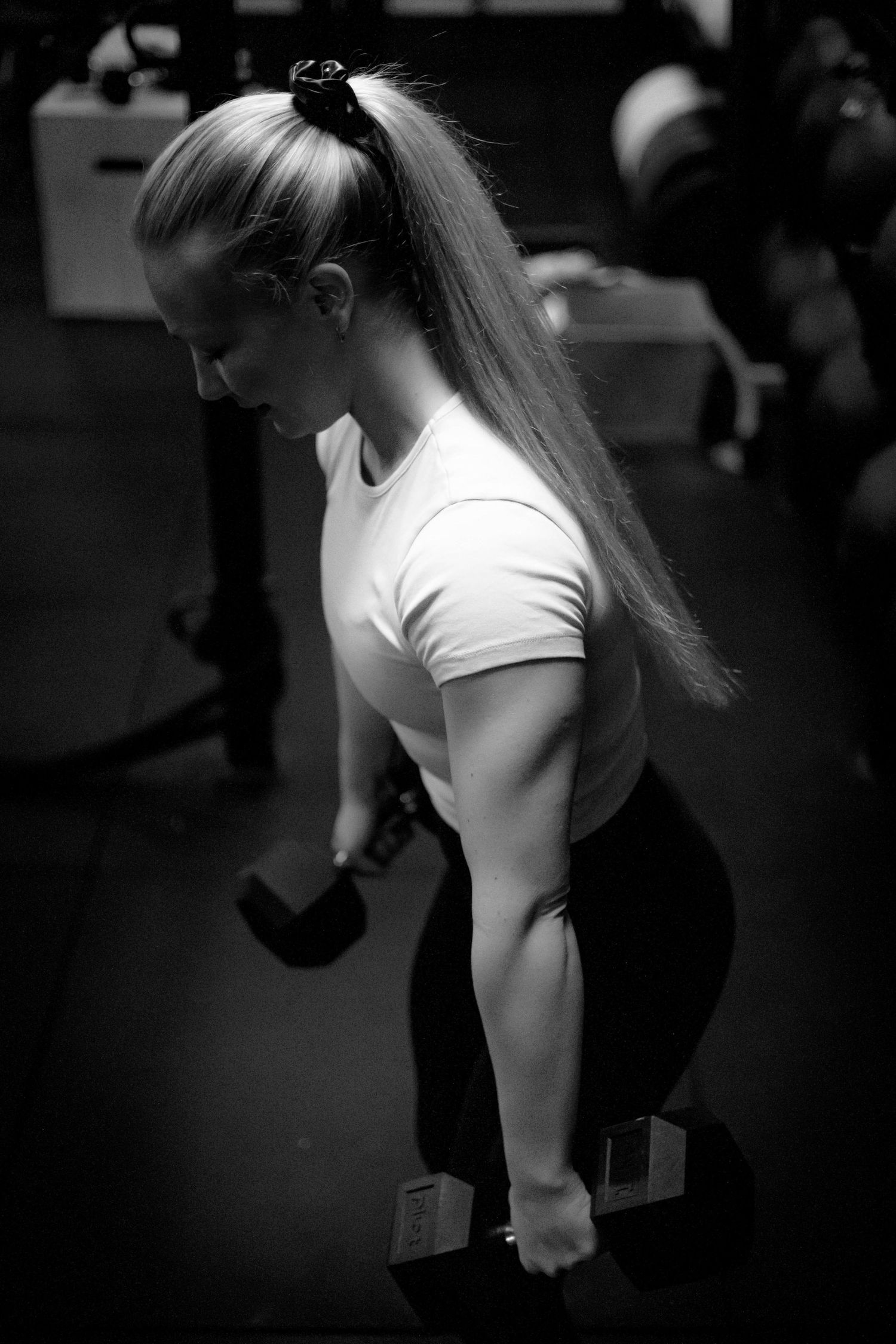 Person in white t-shirt moving in dramatic black and white photography.