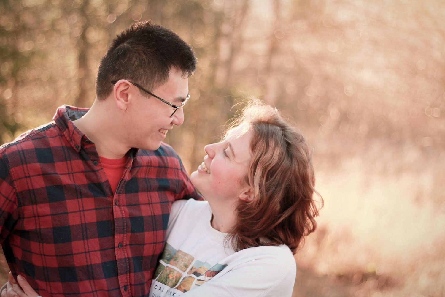 A couple in casual winter attire share an intimate moment in a romantic outdoor photoshoot.