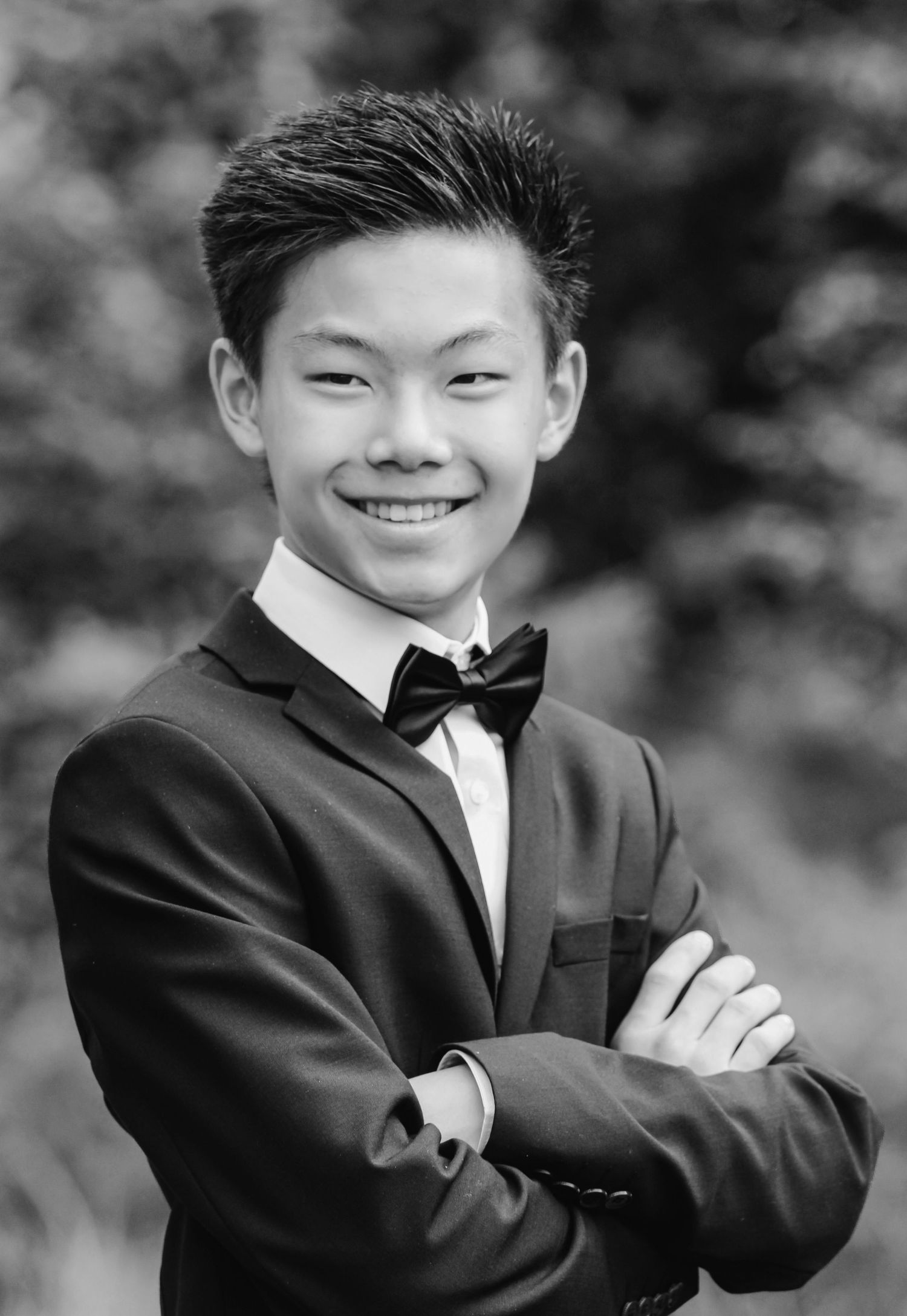 Black and white portrait series showing a young person in formal attire with a bow tie posing confidently.