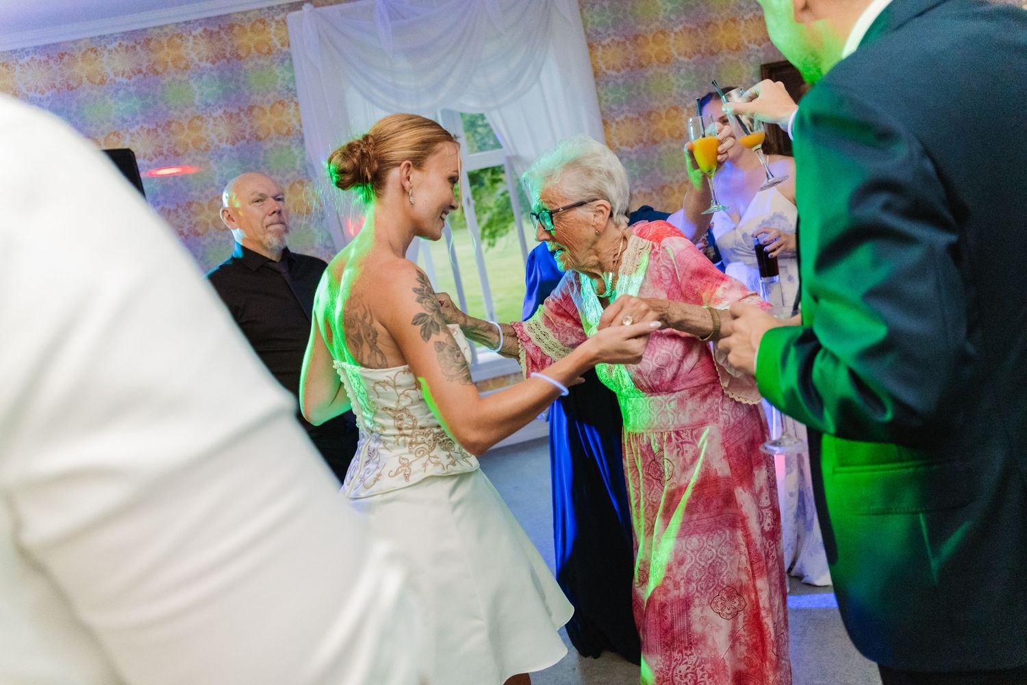 Wedding guests celebrate with colorful powder toss during an outdoor celebration at a joyful ceremony.