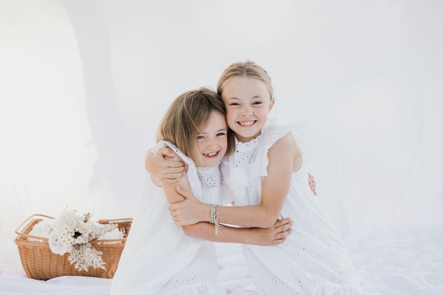 Four tender black and white photos showing intimate family moments with soft lighting and white clothing.