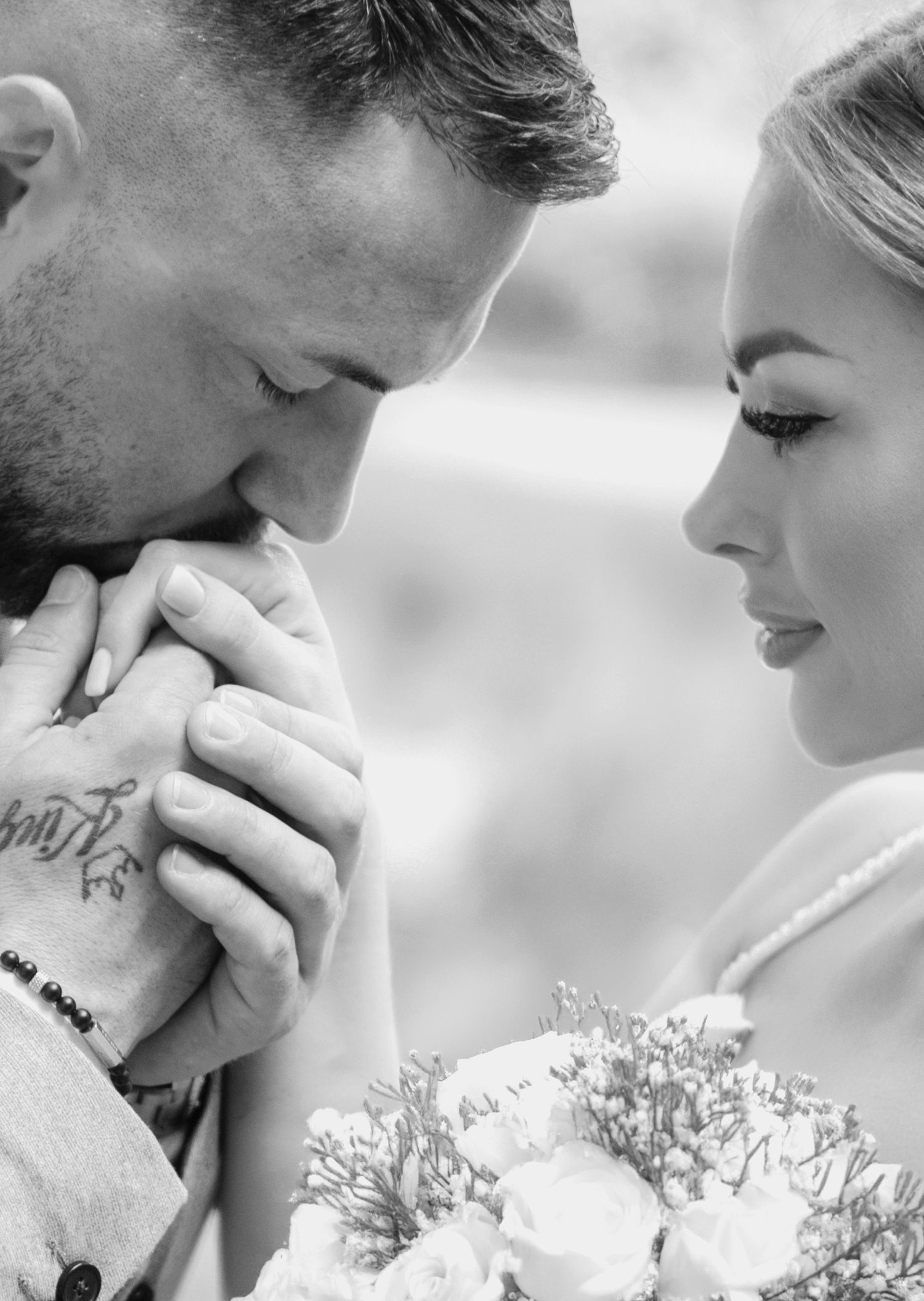 A romantic black and white photo series showing intimate close-up moments with delicate white flowers in the foreground.