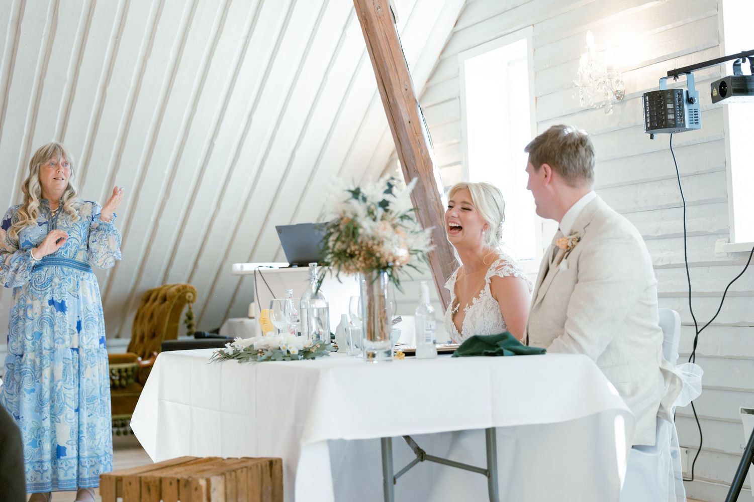 People enjoying a meal together at a white table in a bright, airy dining space.