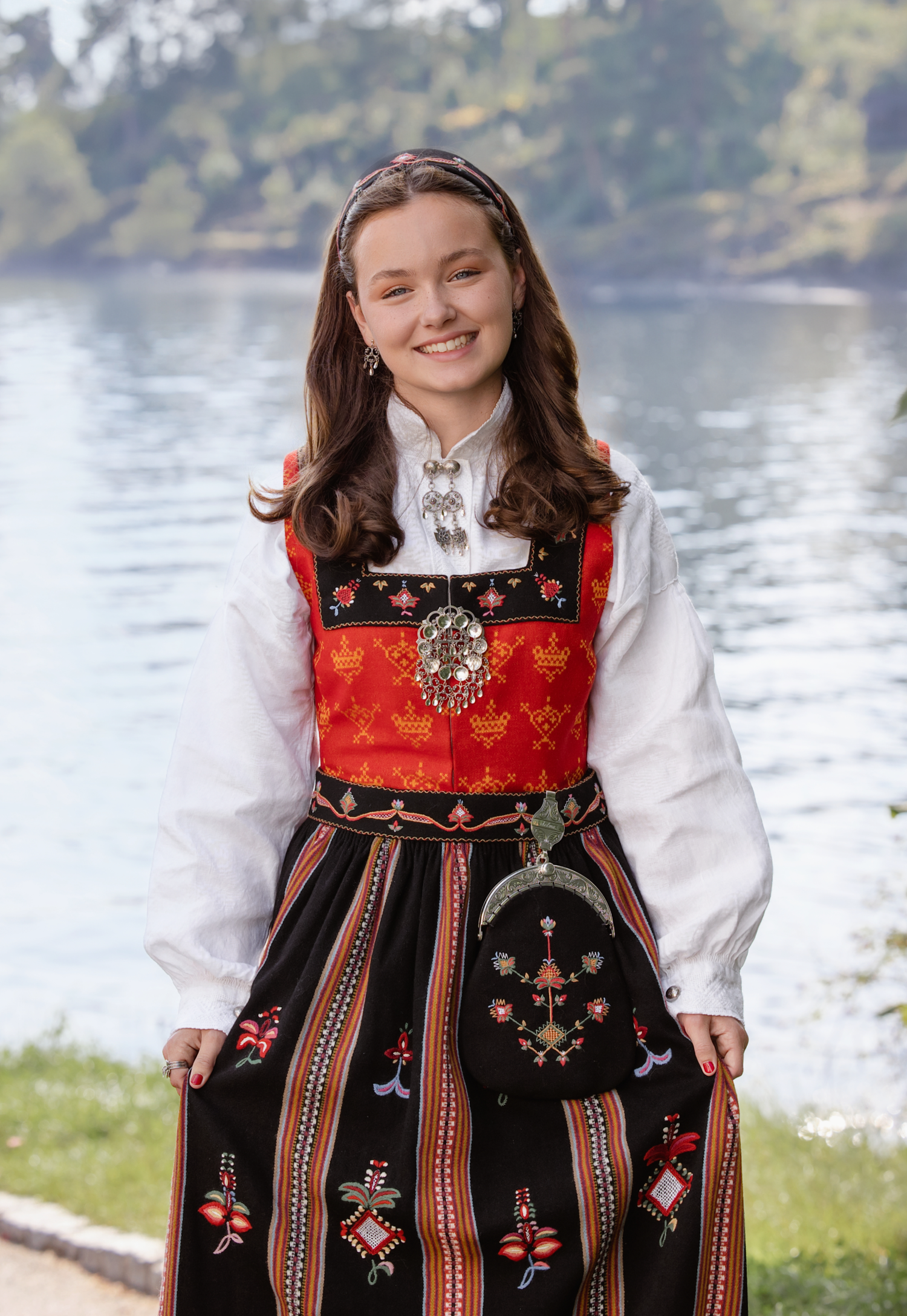 Traditional Norwegian bunad folk dress with embroidered details and red accents shown in multiple views by a lake.