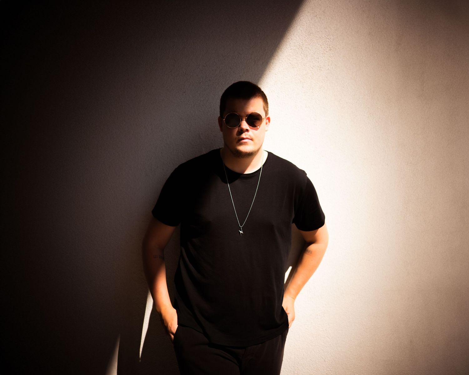 Dramatic portrait series of a person in black clothing against a dark background with dramatic lighting effects.