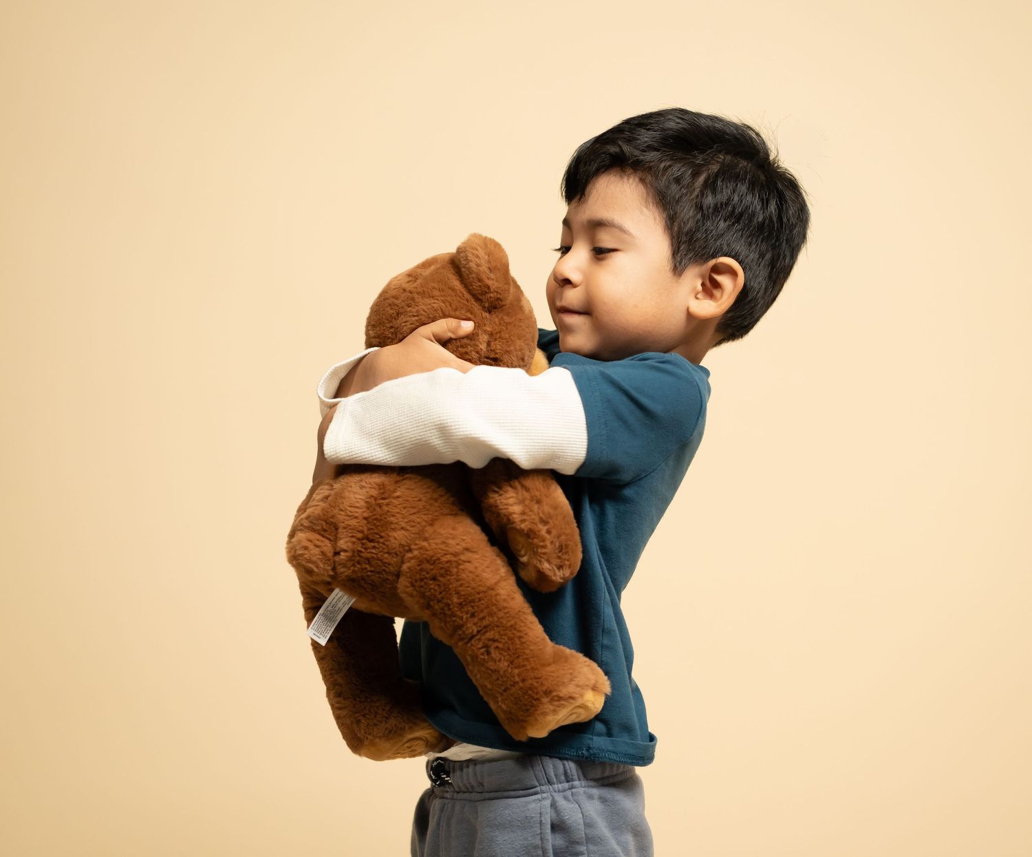 Child hugging teddy bear in studio portrait session in Boise Idaho