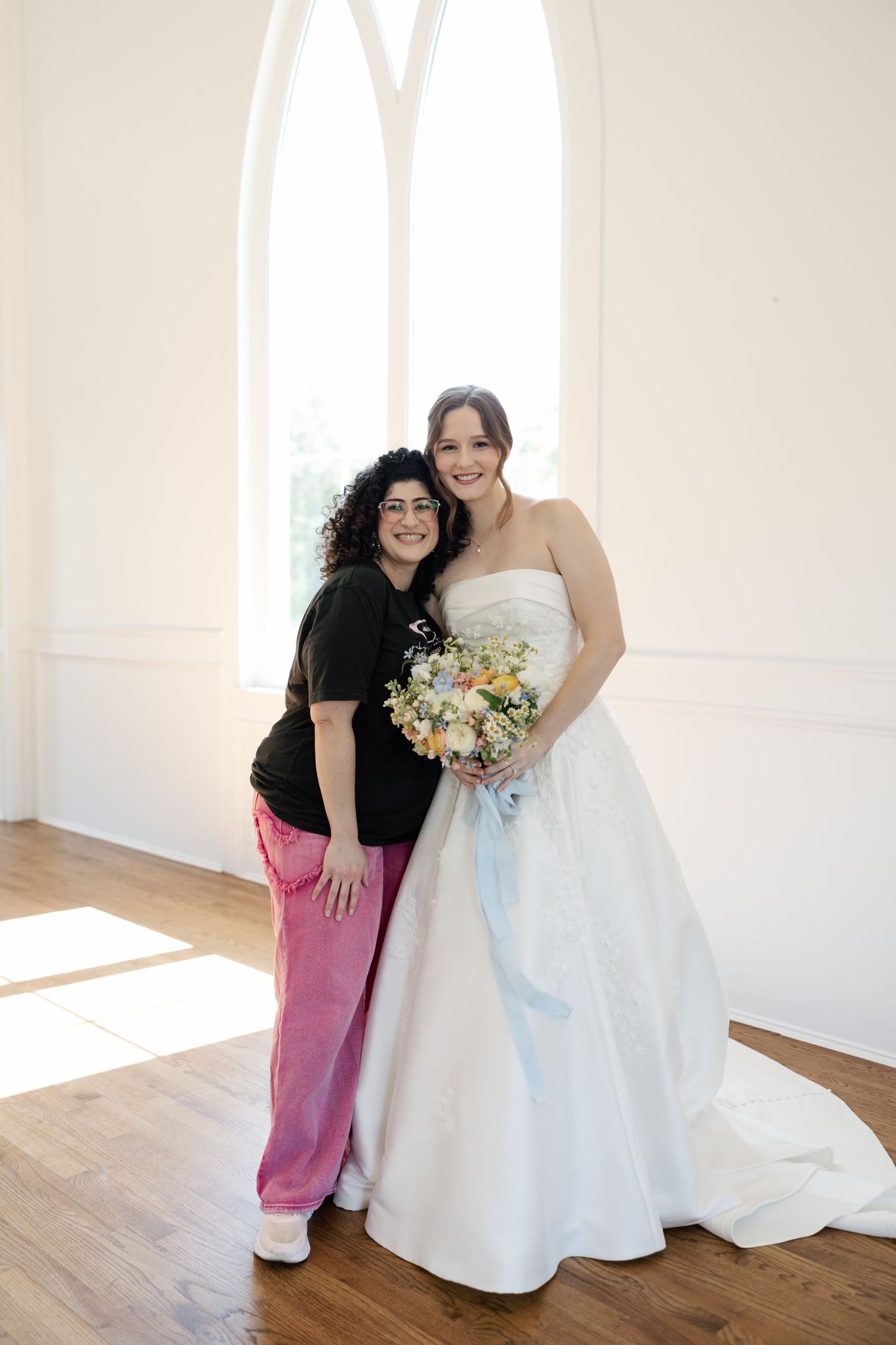 a bride in okc with her makeup artist posing for the photo and happy