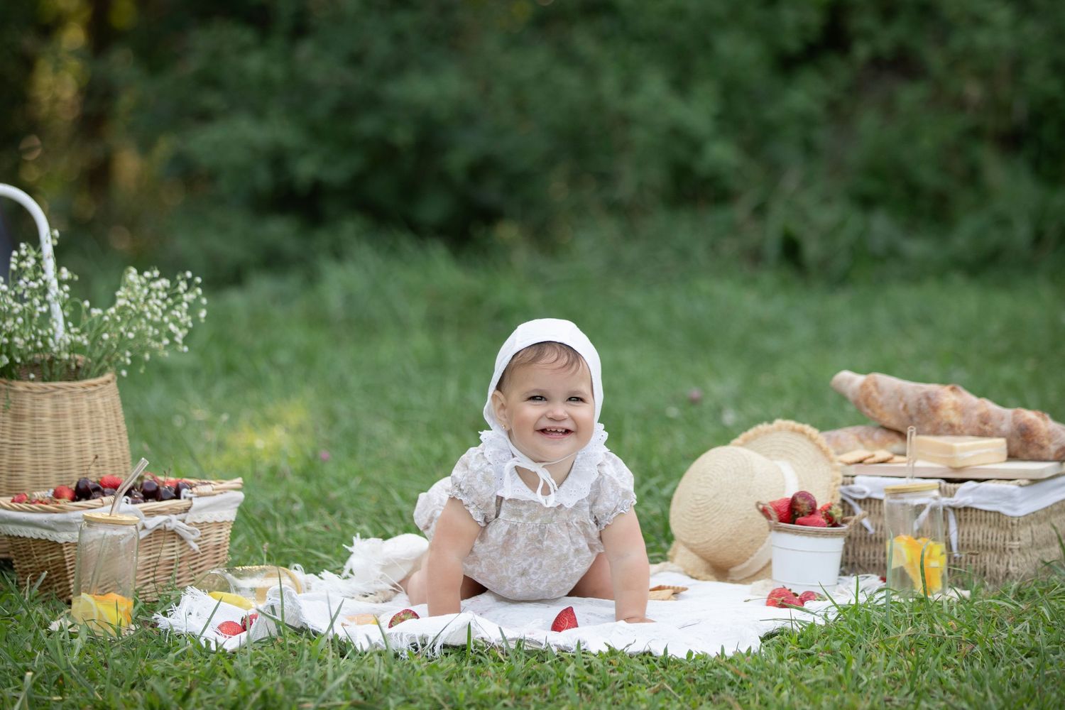 A picturesque picnic setup on a grassy lawn with bread, berries and a woven basket creating a charming outdoor scene.