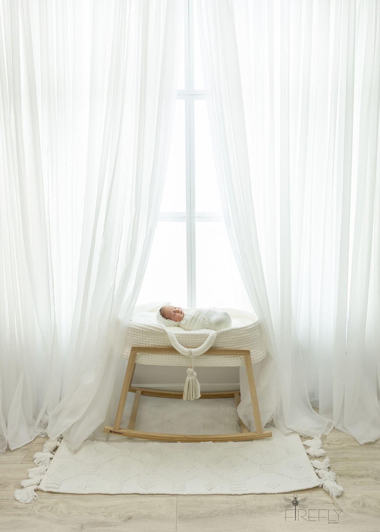 White sheer curtains drape elegantly across a minimalist room with a modern rocking chair and natural light.