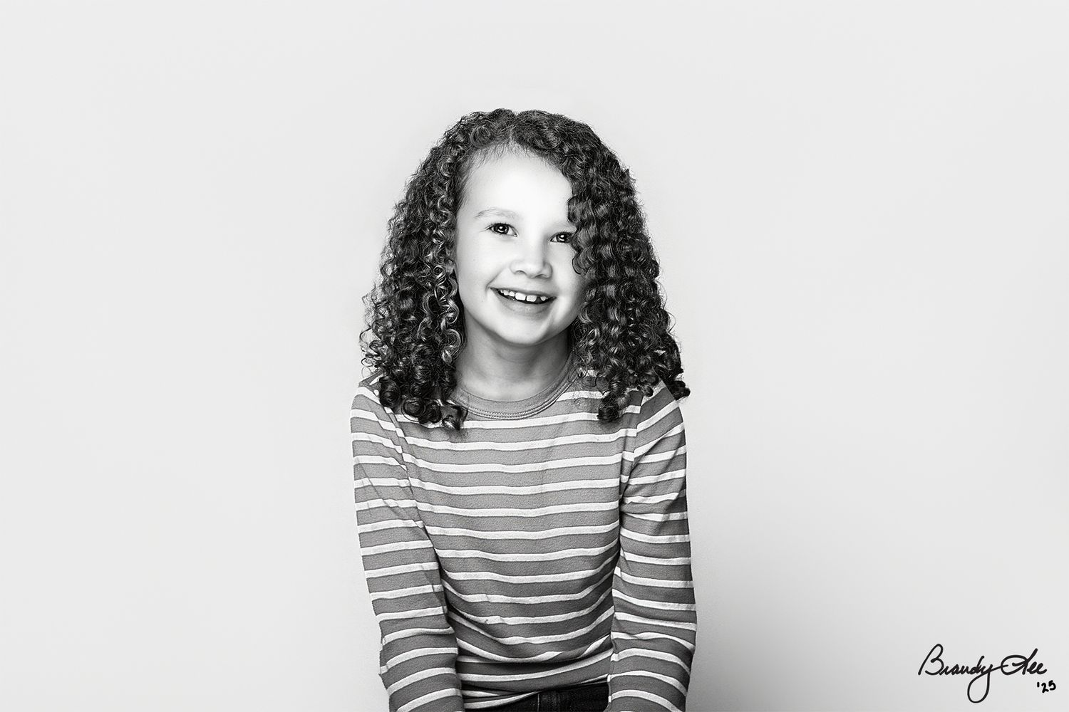 Black and white portrait series showing a person with curly hair wearing a striped shirt against a white background.