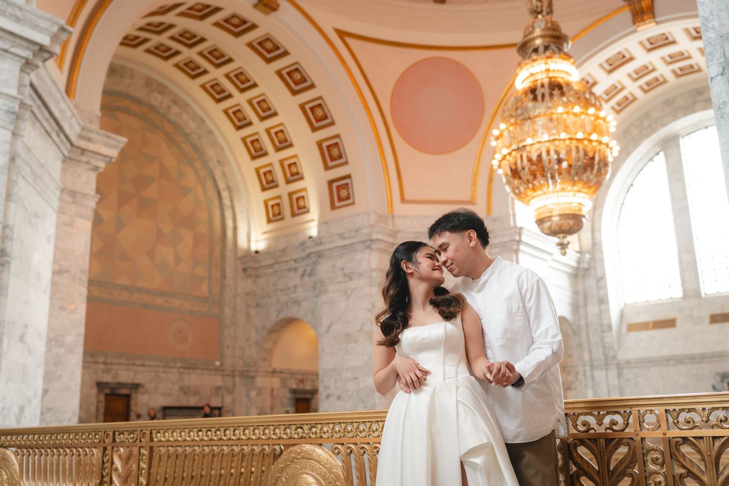 A couple dances together in an ornate ballroom with crystal chandeliers and elegant arched ceilings.