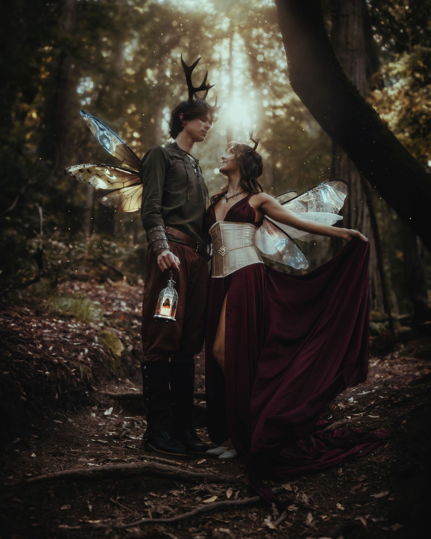 Whimsical fantasy portrait with fairy wings and medieval costumes in a misty forest setting.