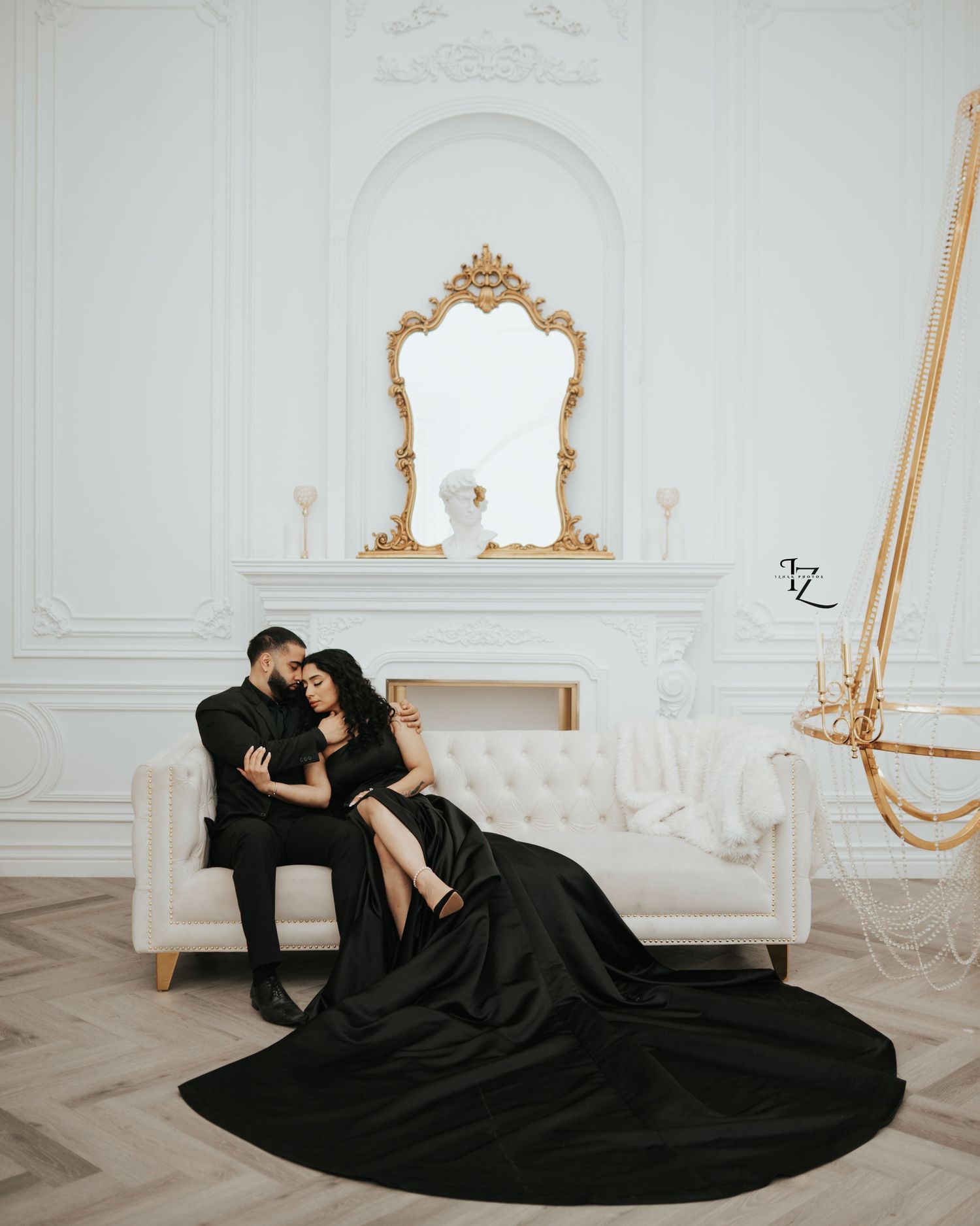 Beautiful Indian couple running hand-in-hand, dressed in elegant black outfits, looking at each other amidst urban city buildings during out