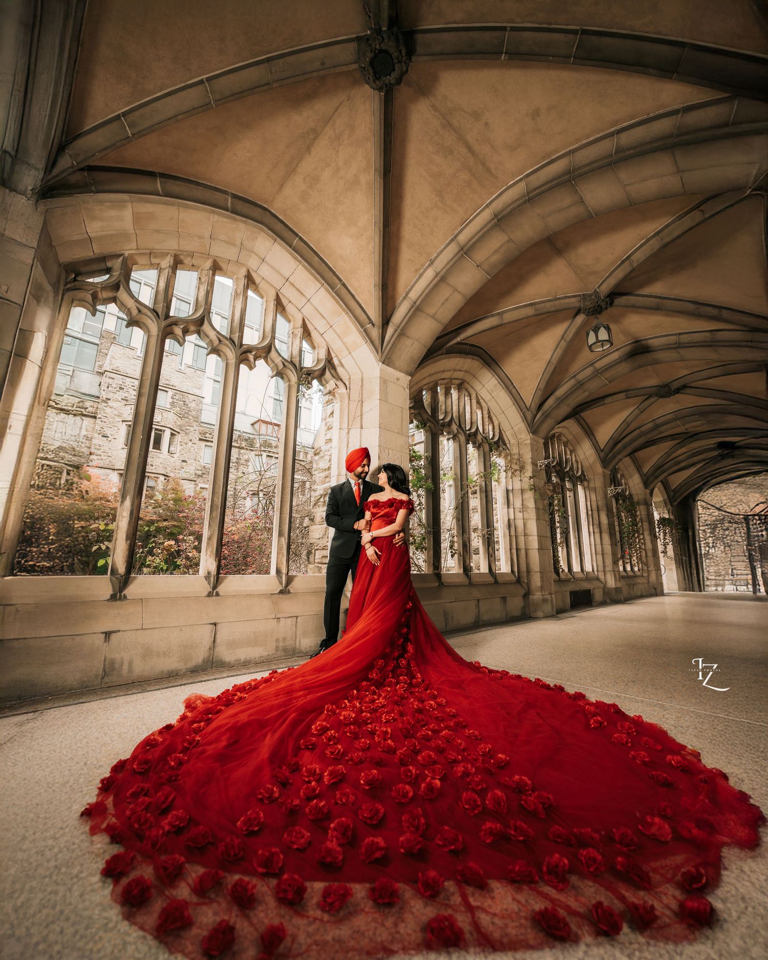 Elegant Punjabi couple at Knox College, bride in flowing red gown against historic architecture
