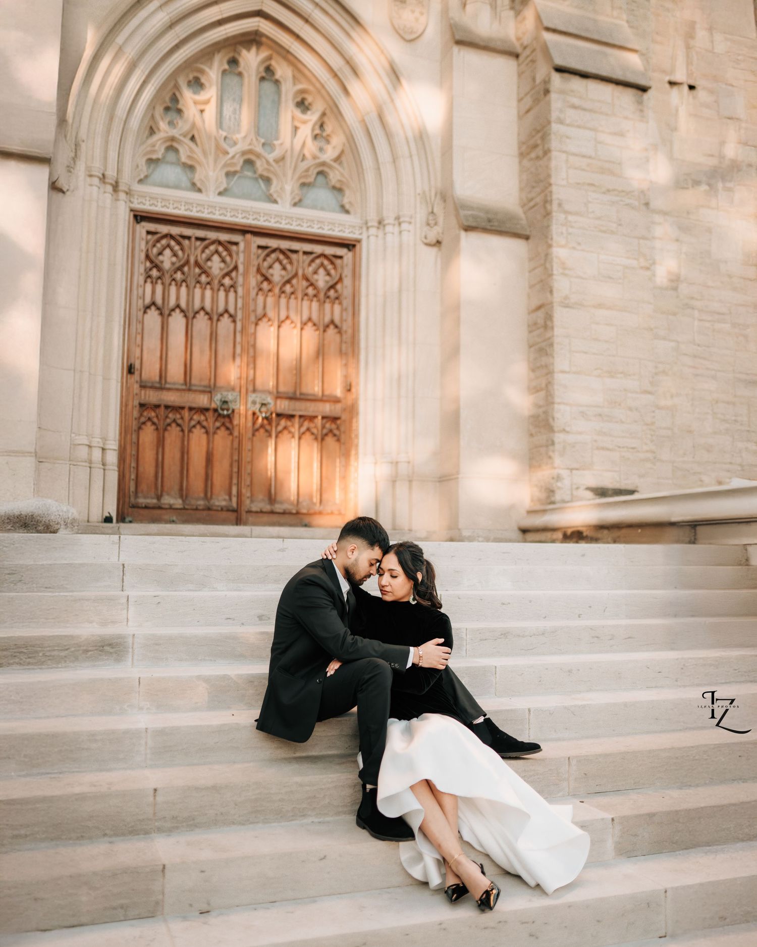 Elegant Indian couple sitting gracefully on stairs during outdoor photoshoot, showcasing romance in toronto