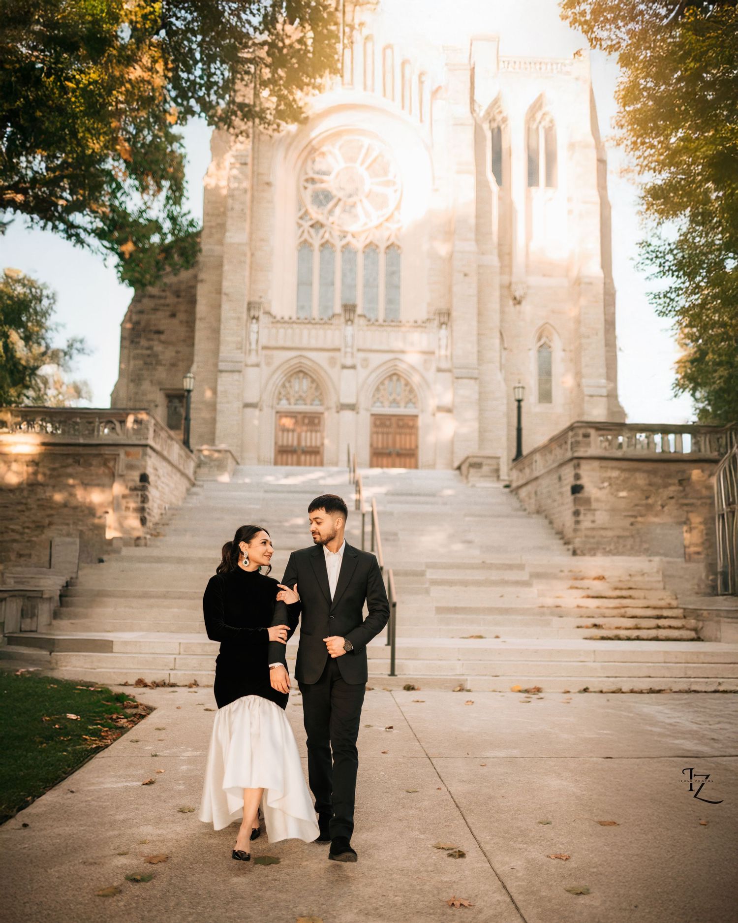 Indian couple walking hand-in-hand in Toronto at sunset, smiling and looking at each other during romantic outdoor engagement photoshoot