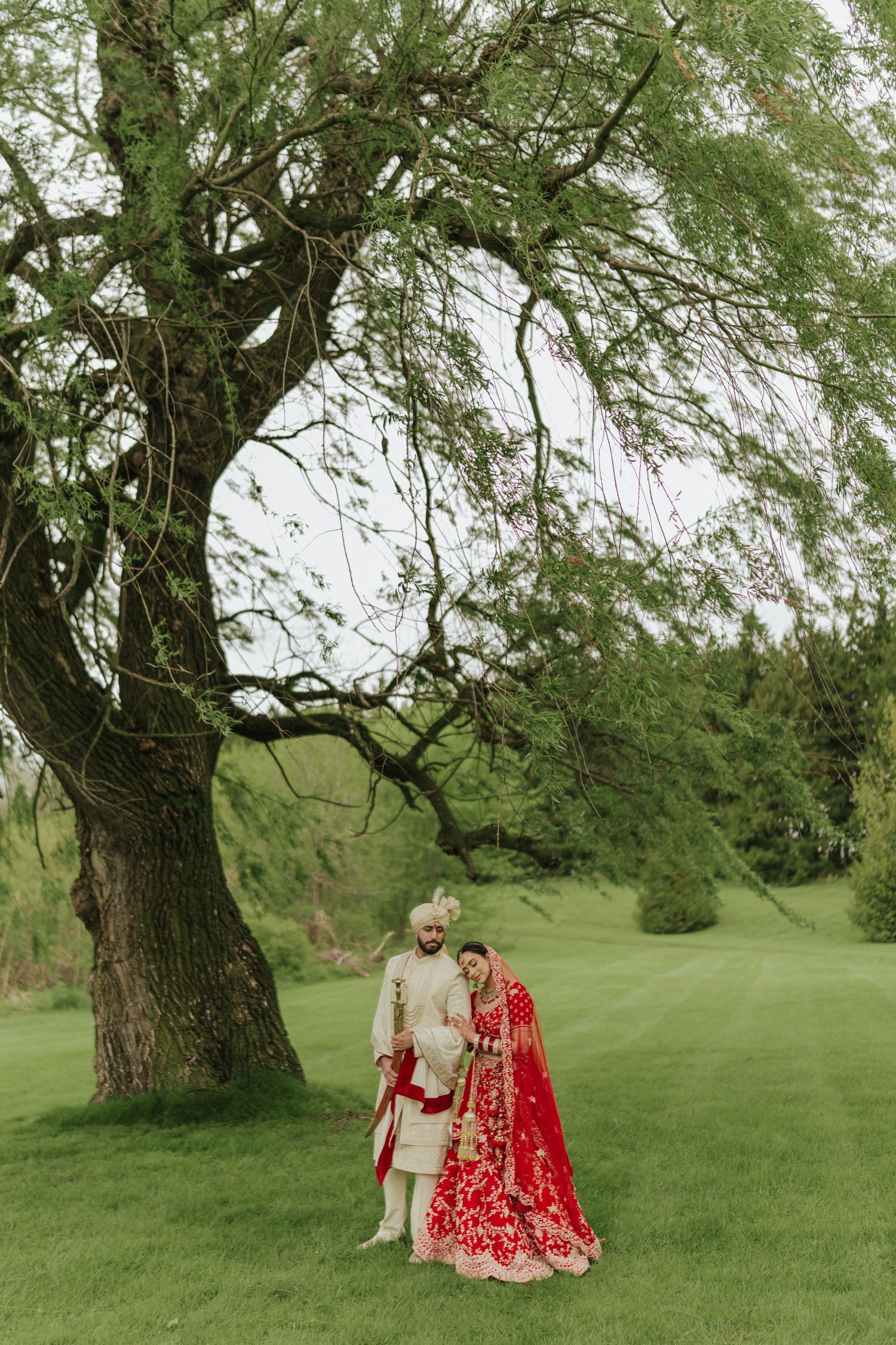 beautiful bride & groom posing together for romantic photoshoot after wedding, showcasing their traditional attire and joyful expressions