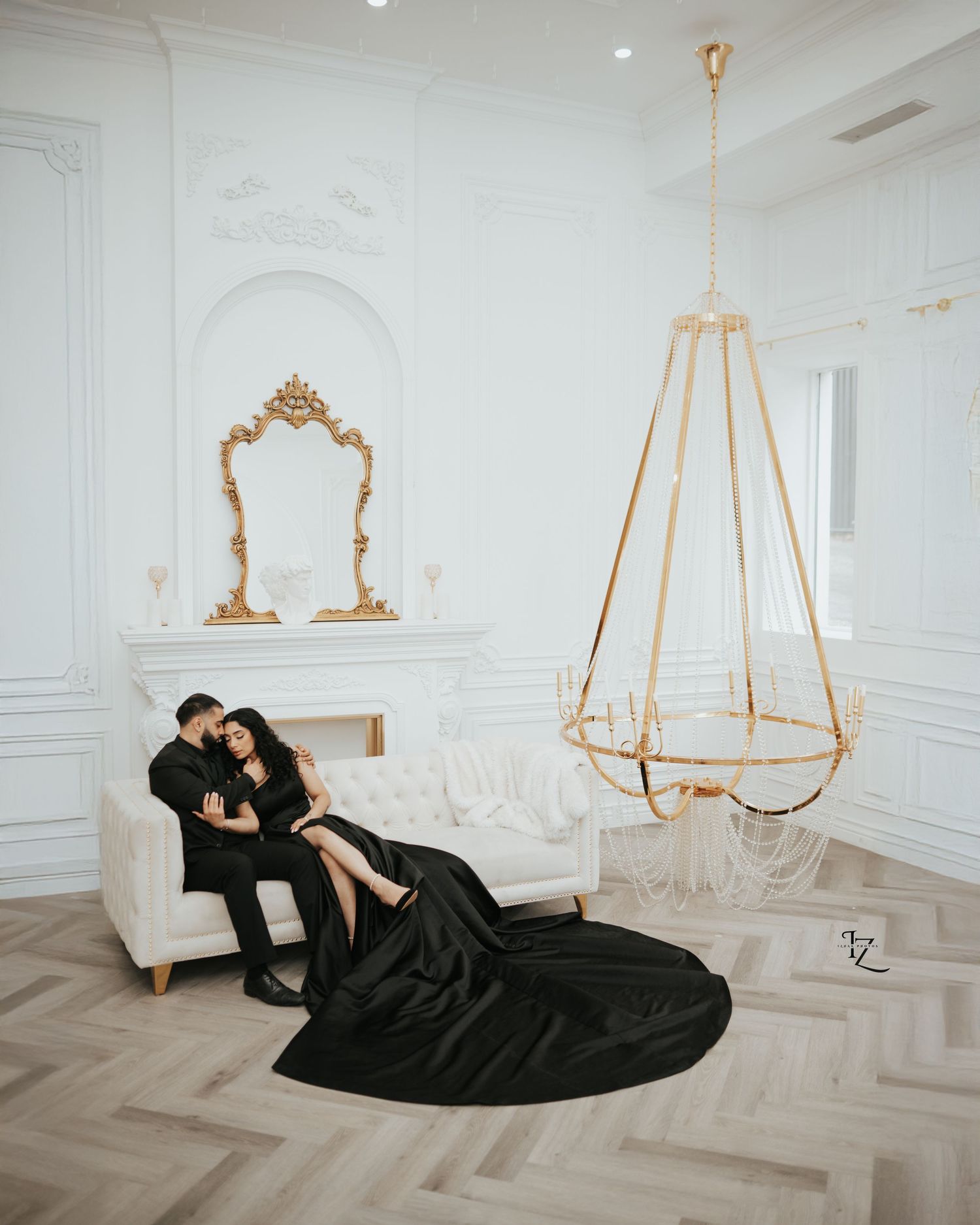 Indian bride and groom captured in elegant indoor studio photoshoot, seated on couch with rich, stylish, and romantic poses in toronto