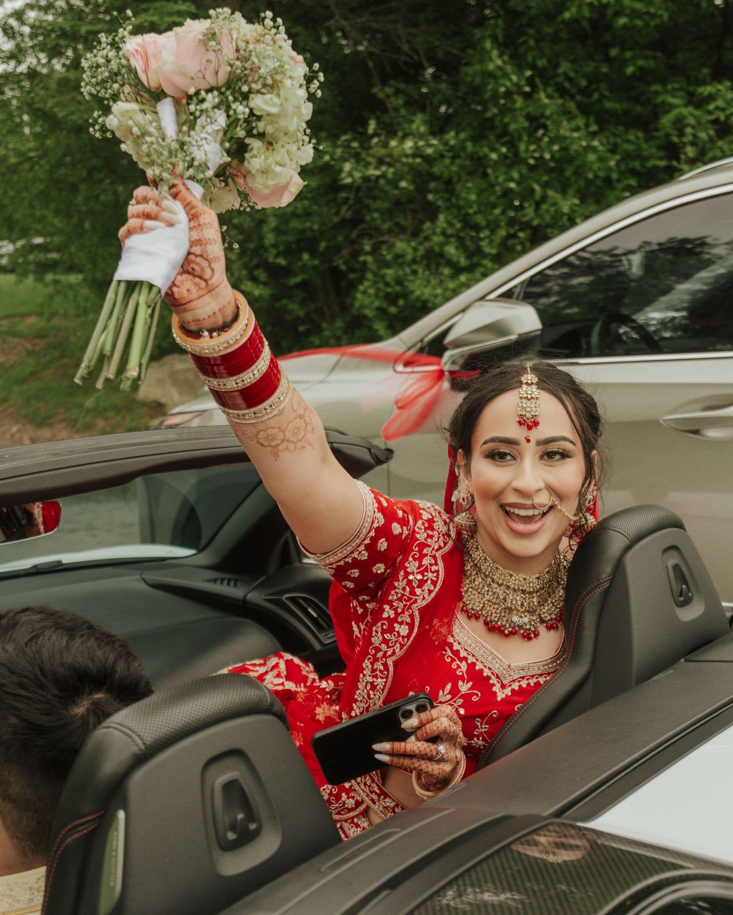 Natural moment capturing bride smiling and moving happily in traditional wedding attire