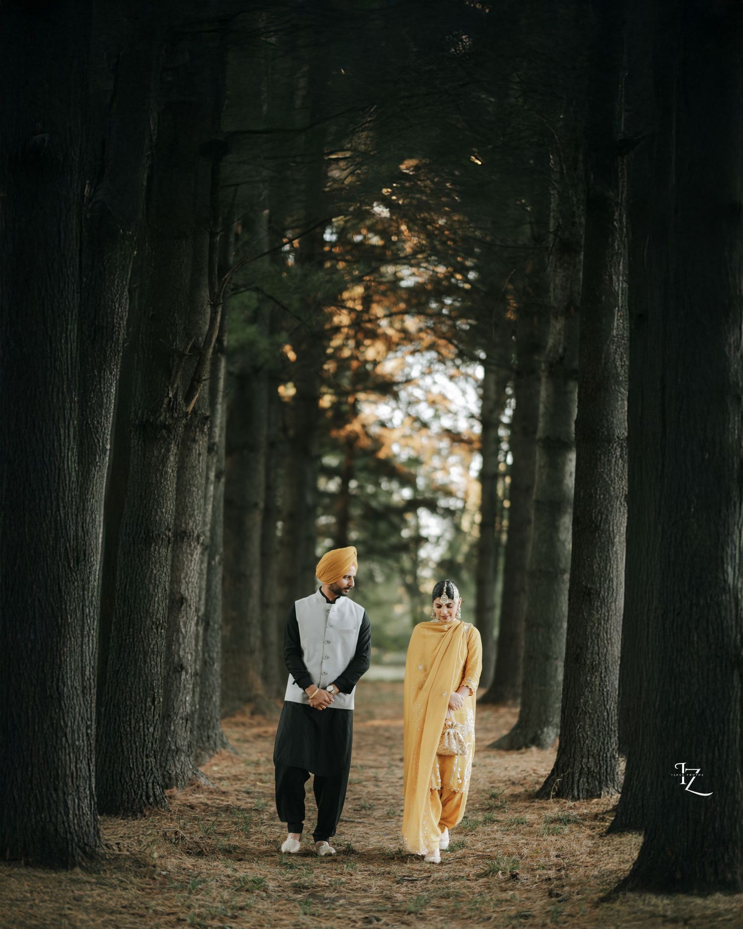 Smiling Punjabi couple feeling shy while walking together, groom wearing kurta pajama and bride in suit in toronto