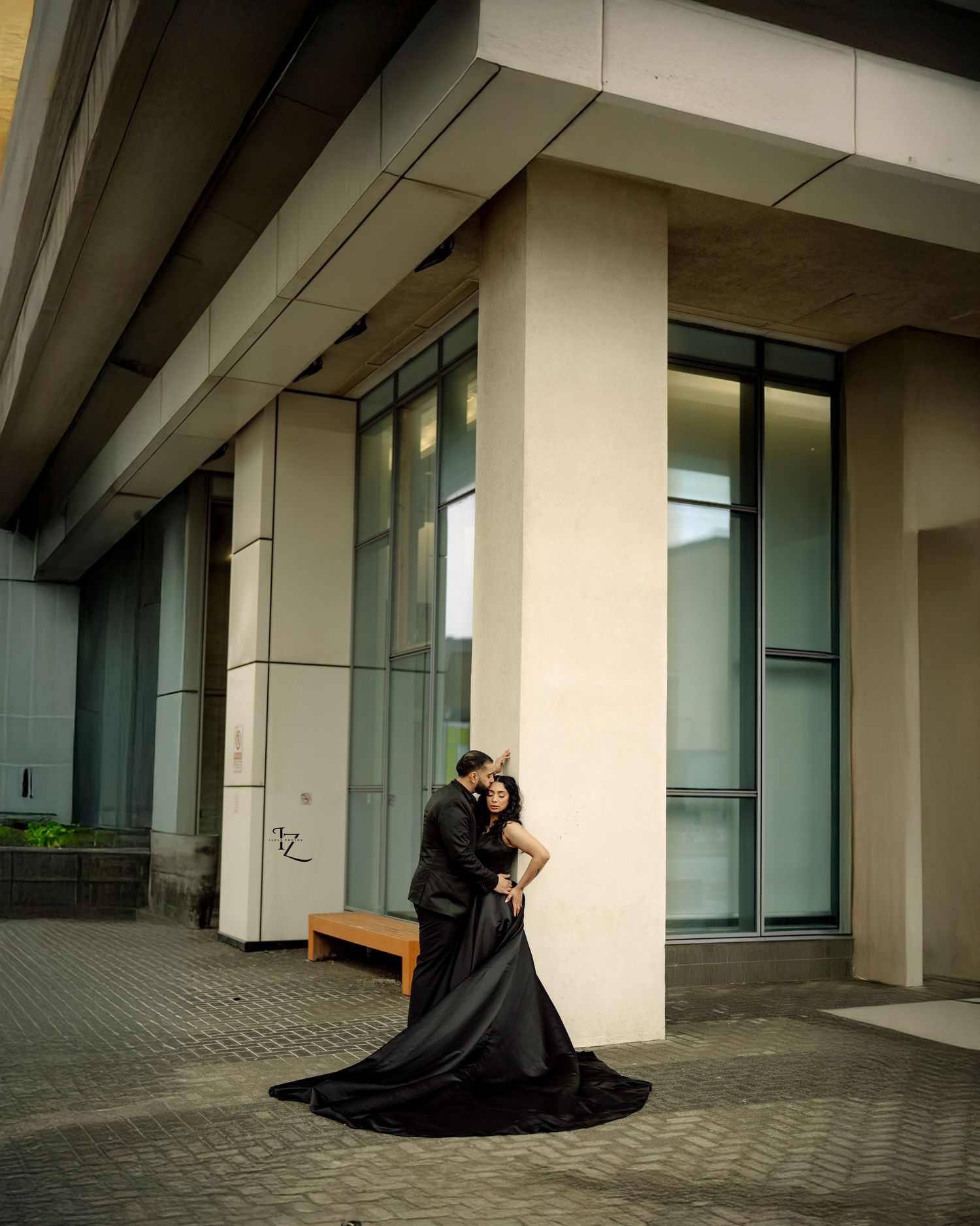 Elegant Indian couple striking a sophisticated pose near urban building wall during stylish outdoor photoshoot