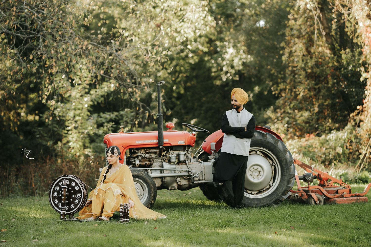 Punjabi girl using a charkha while boy stands nearby watching, beside a tractor in a rustic outdoor setting in toronto