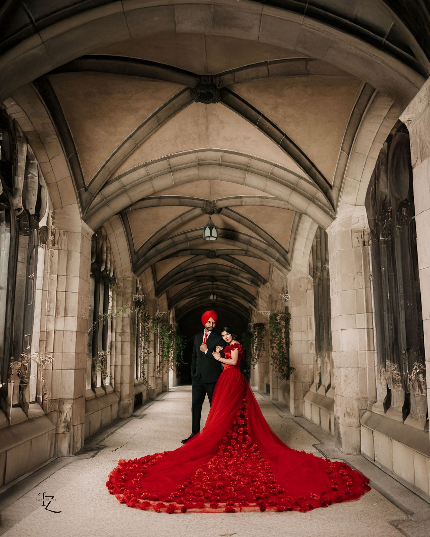 Stylish South Asian couple posing at Knox College, bride in deep red dress, capturing timeless romance