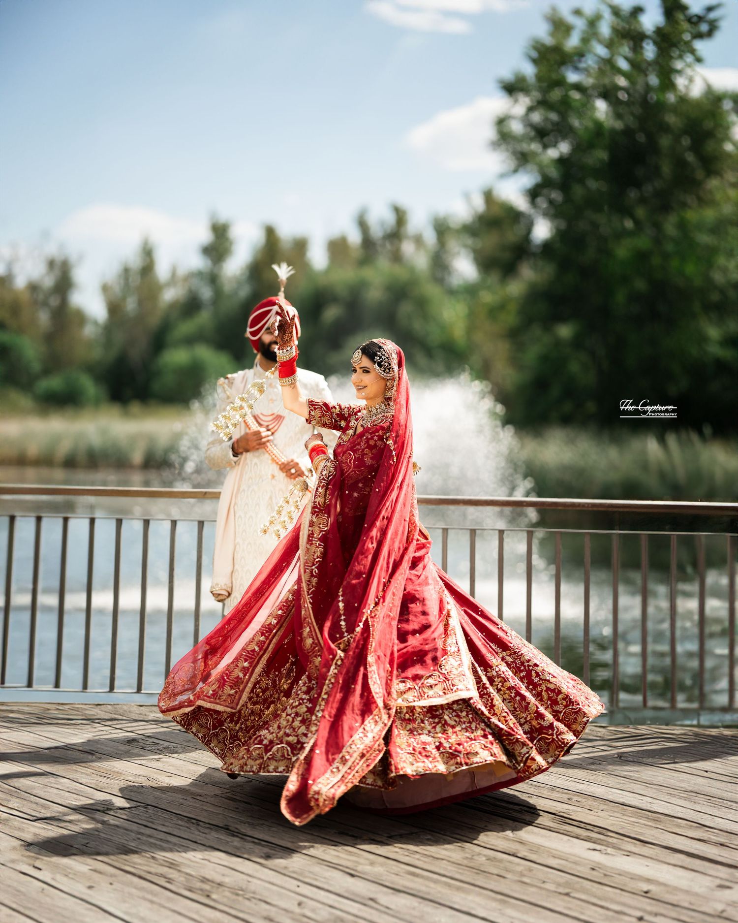 Indian bride twirling elegantly in traditional bridal dress during outdoor photoshoot, highlighting cultural beauty & motion in toronto