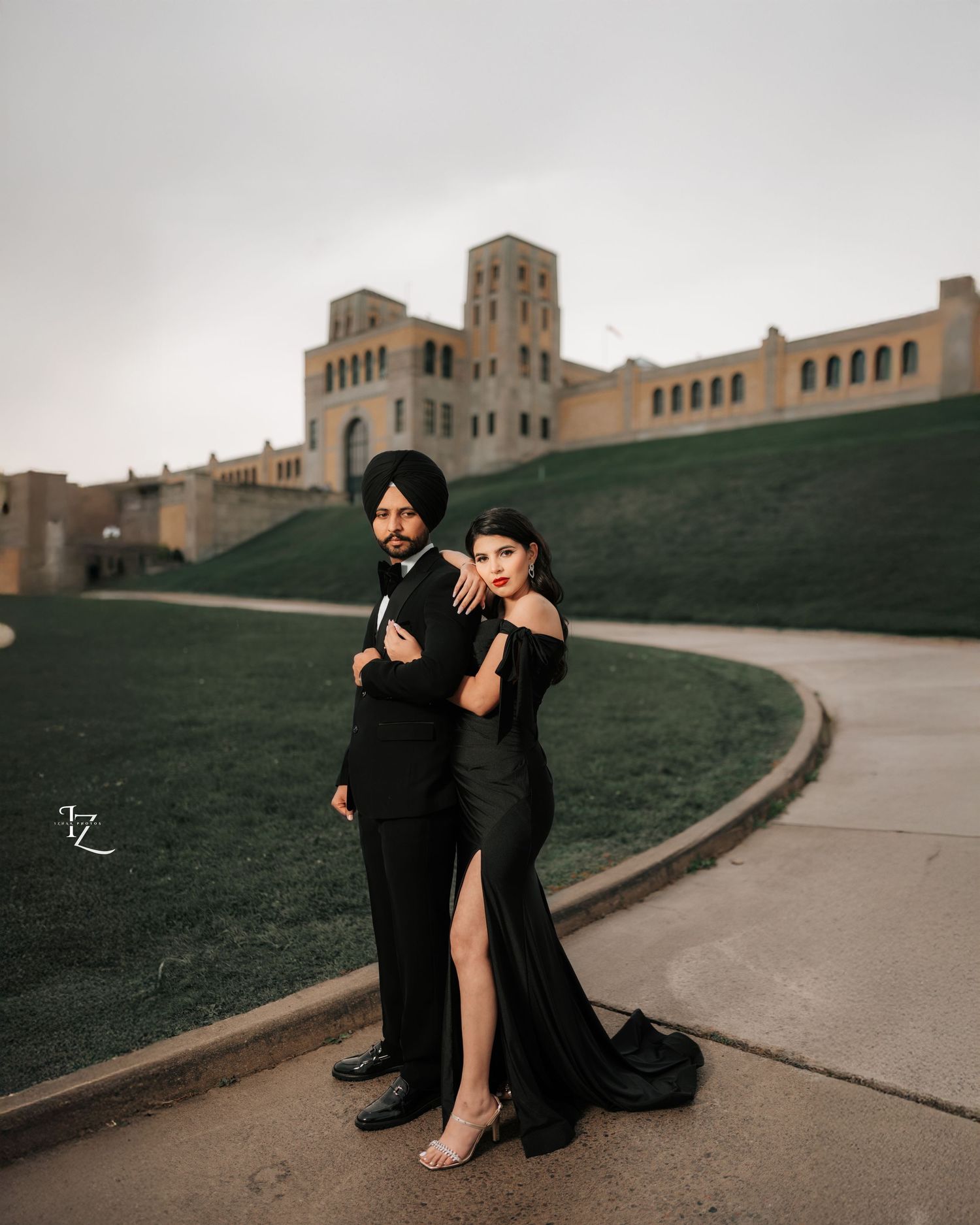 Stylish couple in black outfits striking a model-inspired pose during engagement photoshoot