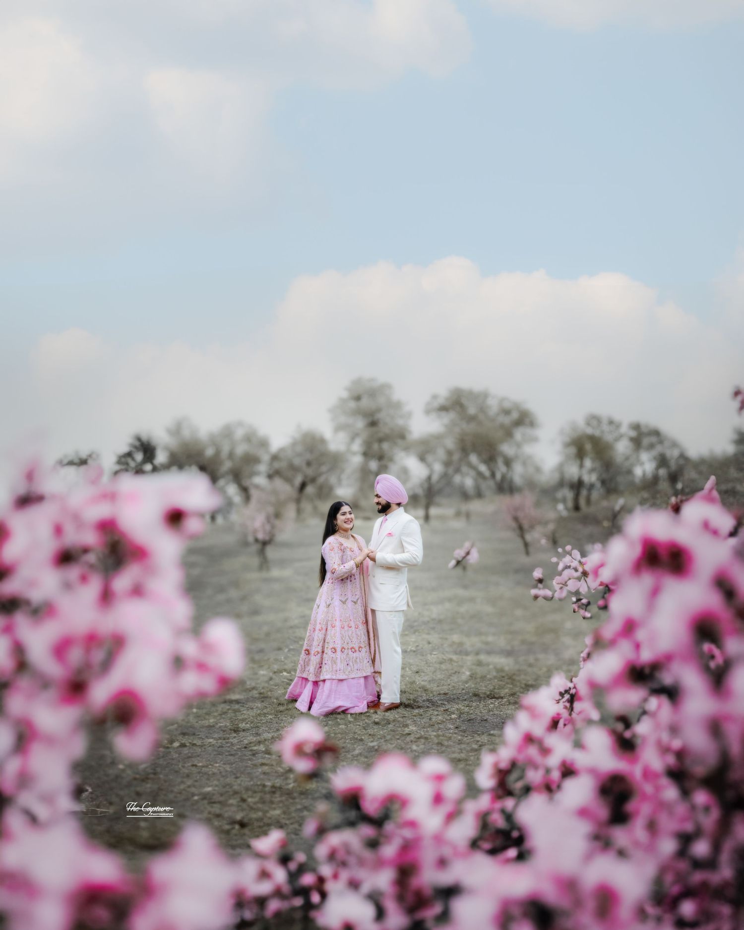 Candid moment of couple smiling during cherry blossom pre-wedding photoshoot in Brampton, Toronto, ontario, canada