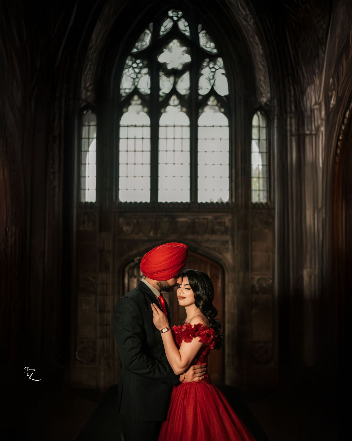 Graceful Punjabi couple at Knox College, toronto , bride wearing a flowing red gown framed by historic architecture