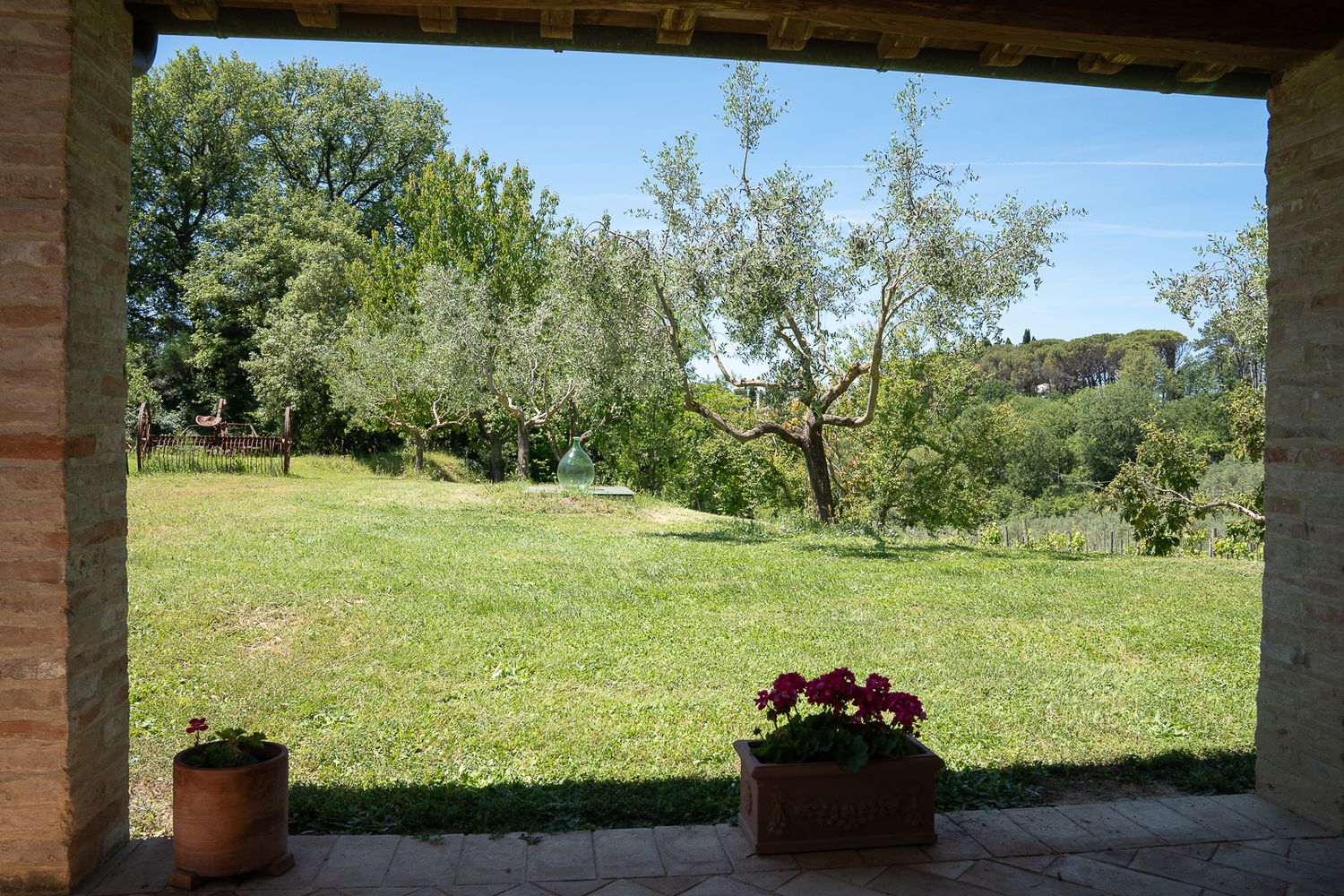 Covered patio with terracotta pots and scenic countryside views.