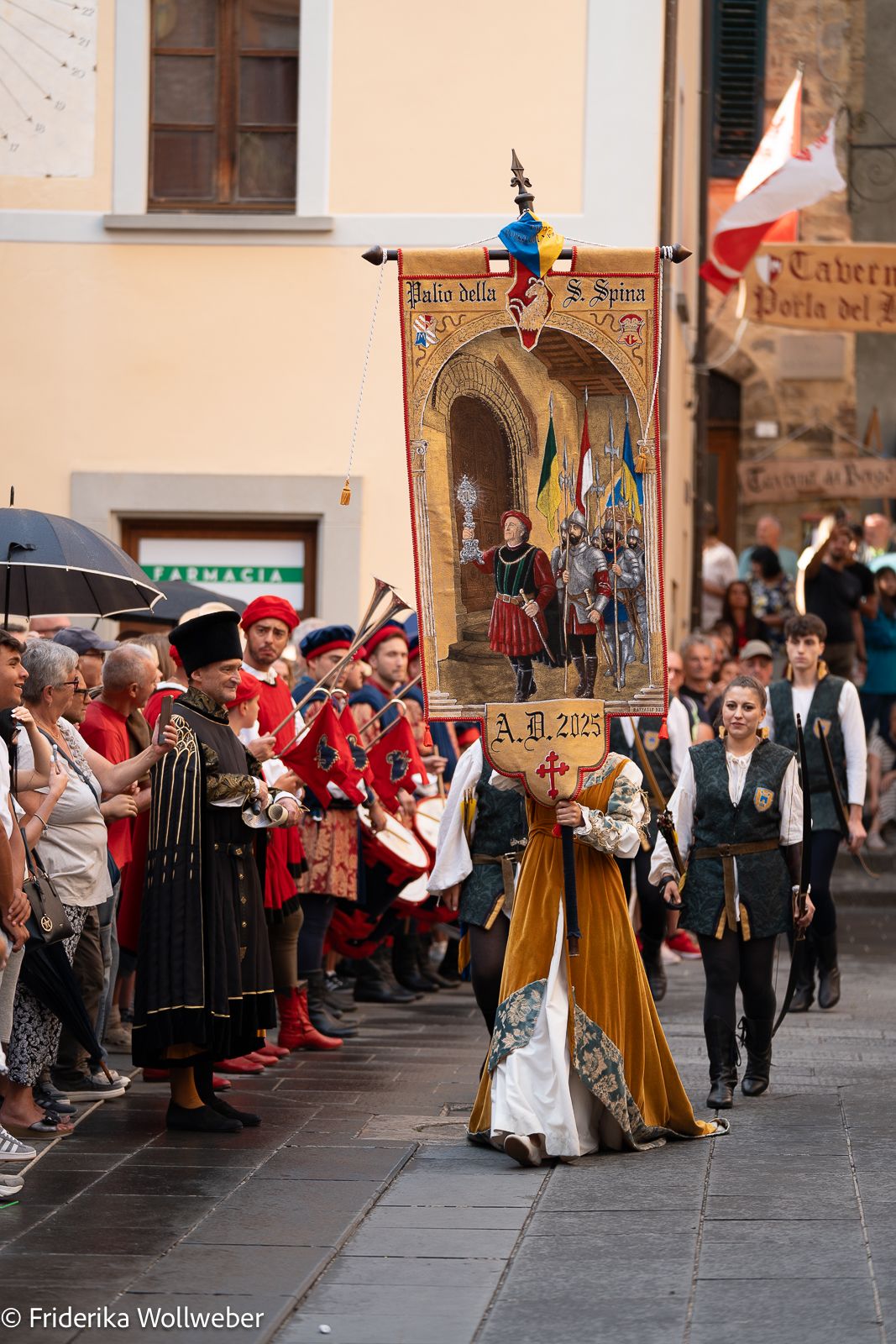 Medieval festival parade with costumed performers in traditional dress through Montone town square.