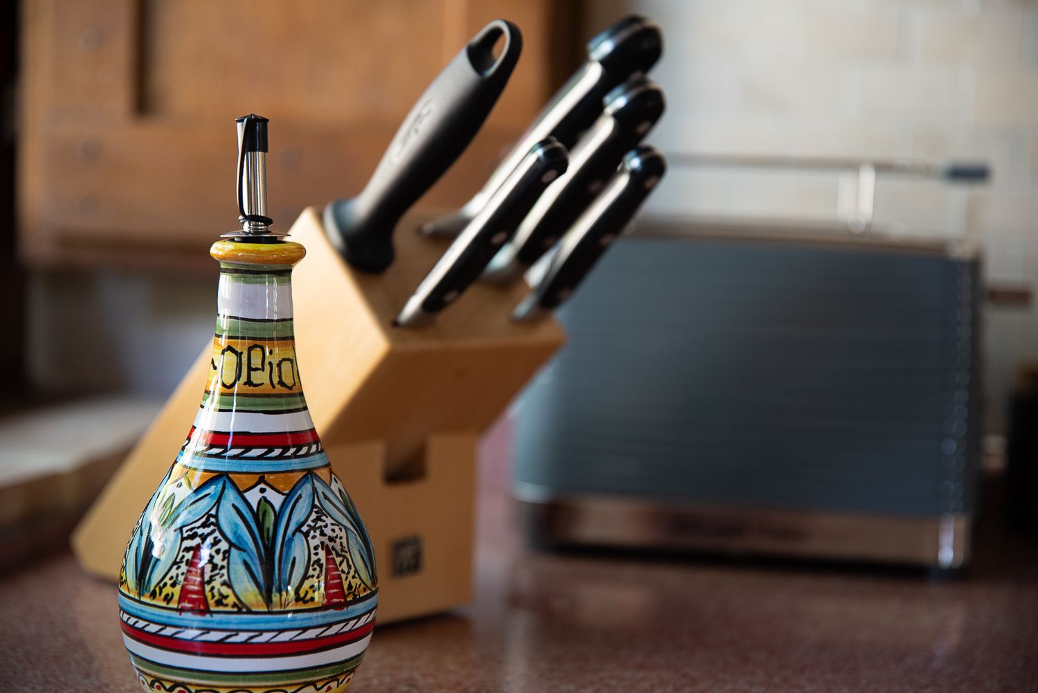 Colorful hand-painted ceramic dispensers and decorative items displayed on a wooden surface.