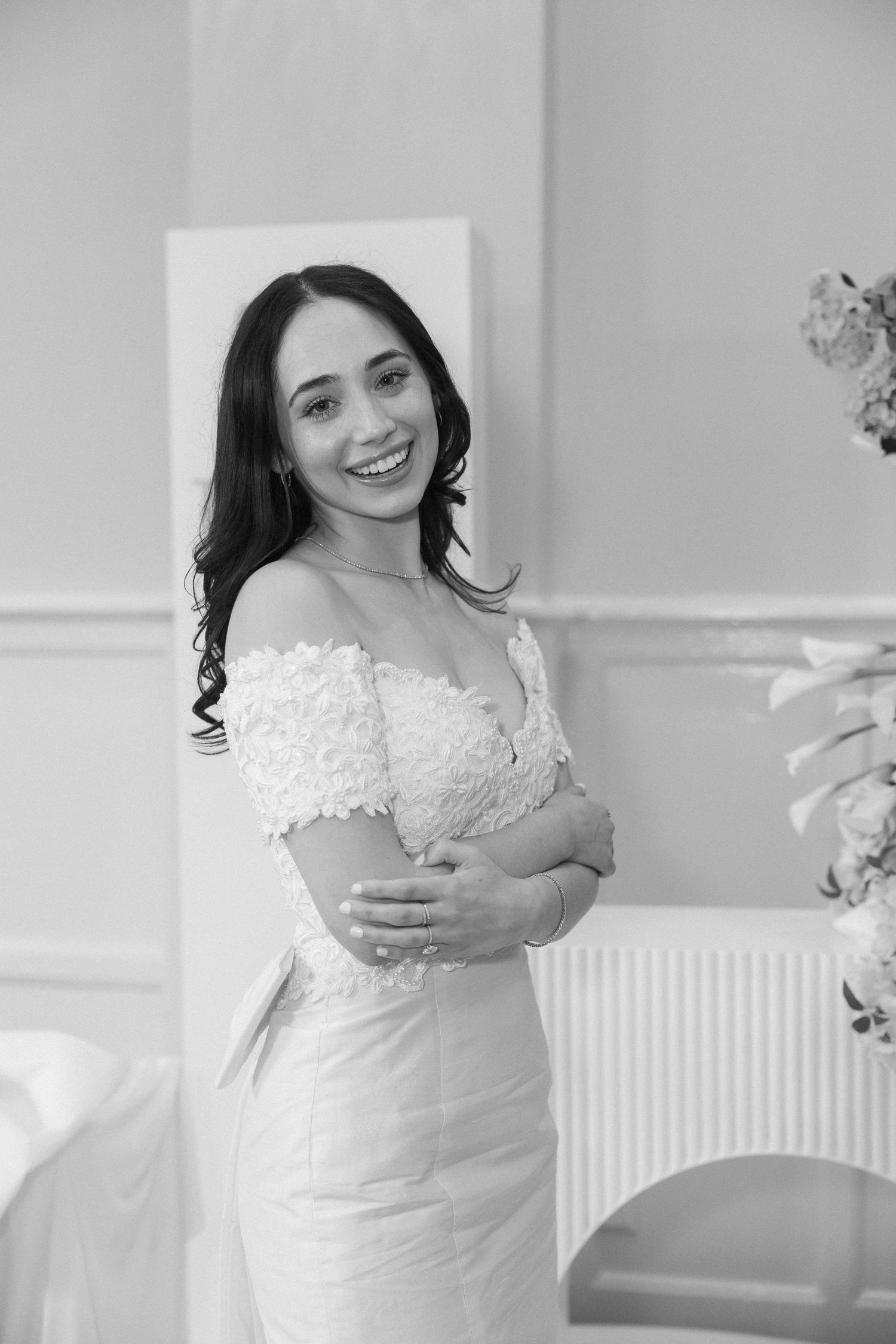 Elegant white lace wedding dress detail captured in black and white photography.