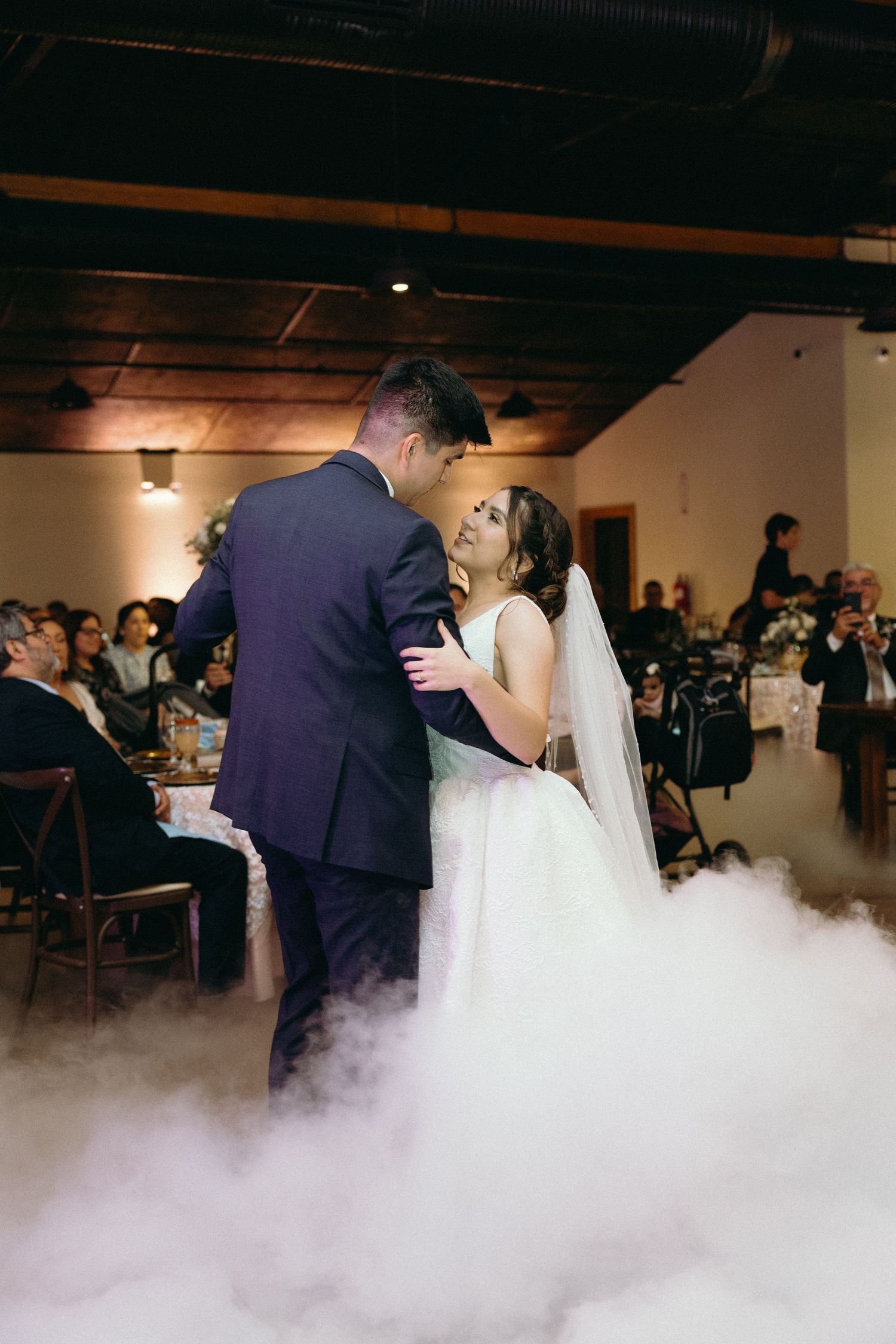 First dance moment surrounded by atmospheric fog effects on the dance floor.
