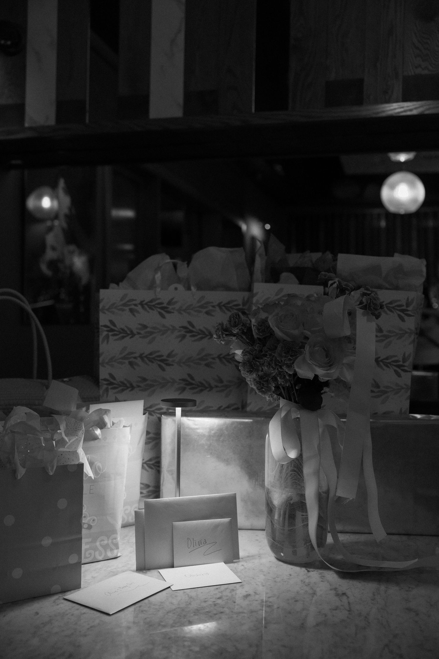 Black and white image showing illuminated cardboard boxes arranged on a dark surface.