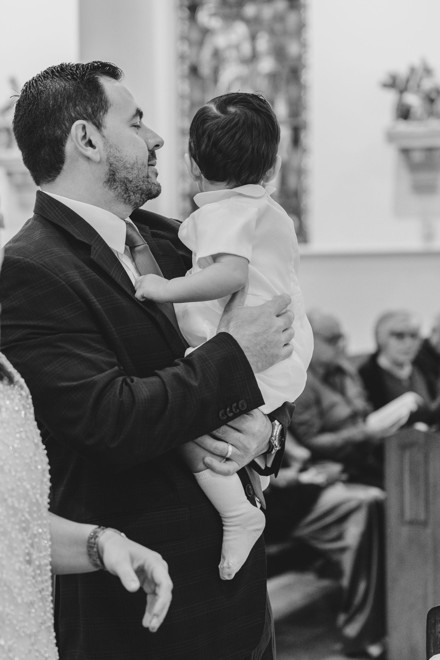 Black and white photo of formal event with people holding infants.