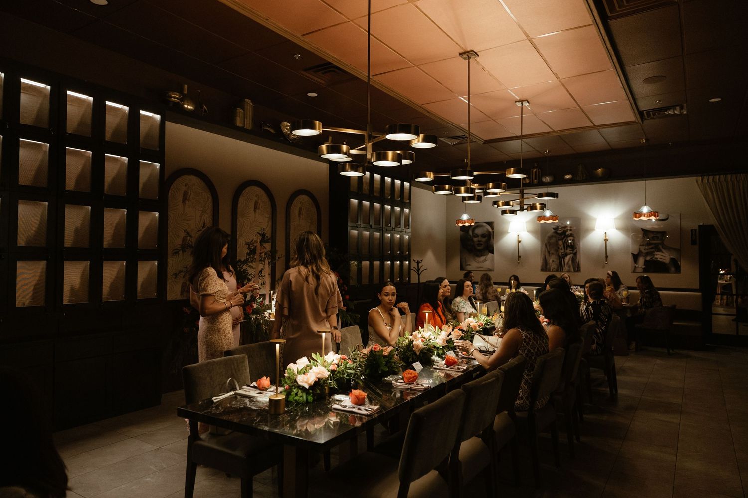 Dark interior view of an elegantly decorated event space with ambient lighting.