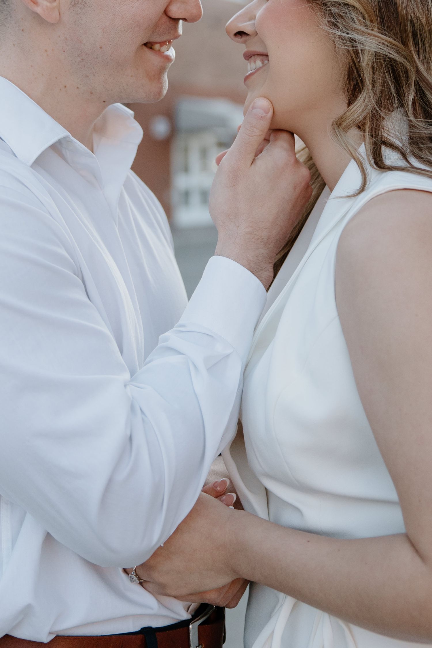 Romantic close-up portrait of a couple in white clothing sharing an intimate moment together.