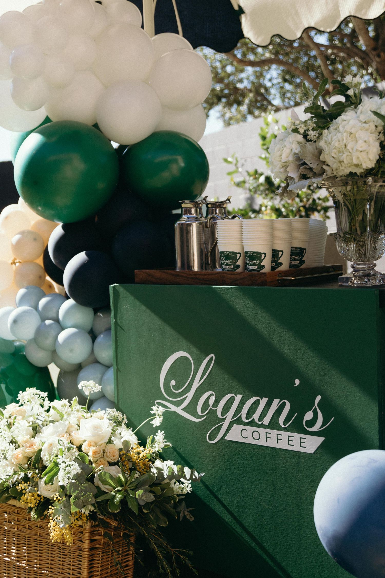 Coffee-themed party setup with green signage and white balloon decorations.