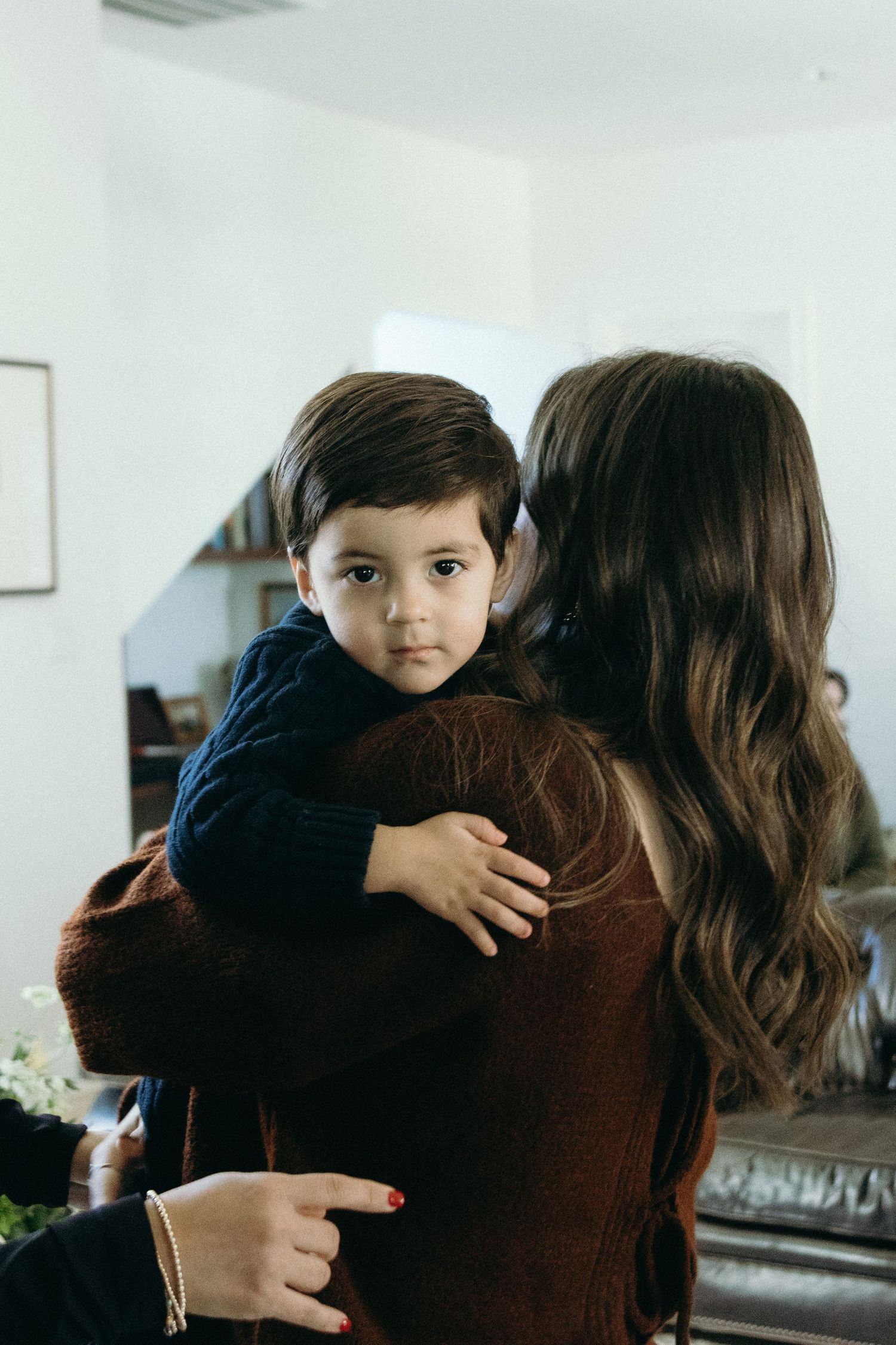 A tender moment captured indoors showing an emotional embrace.