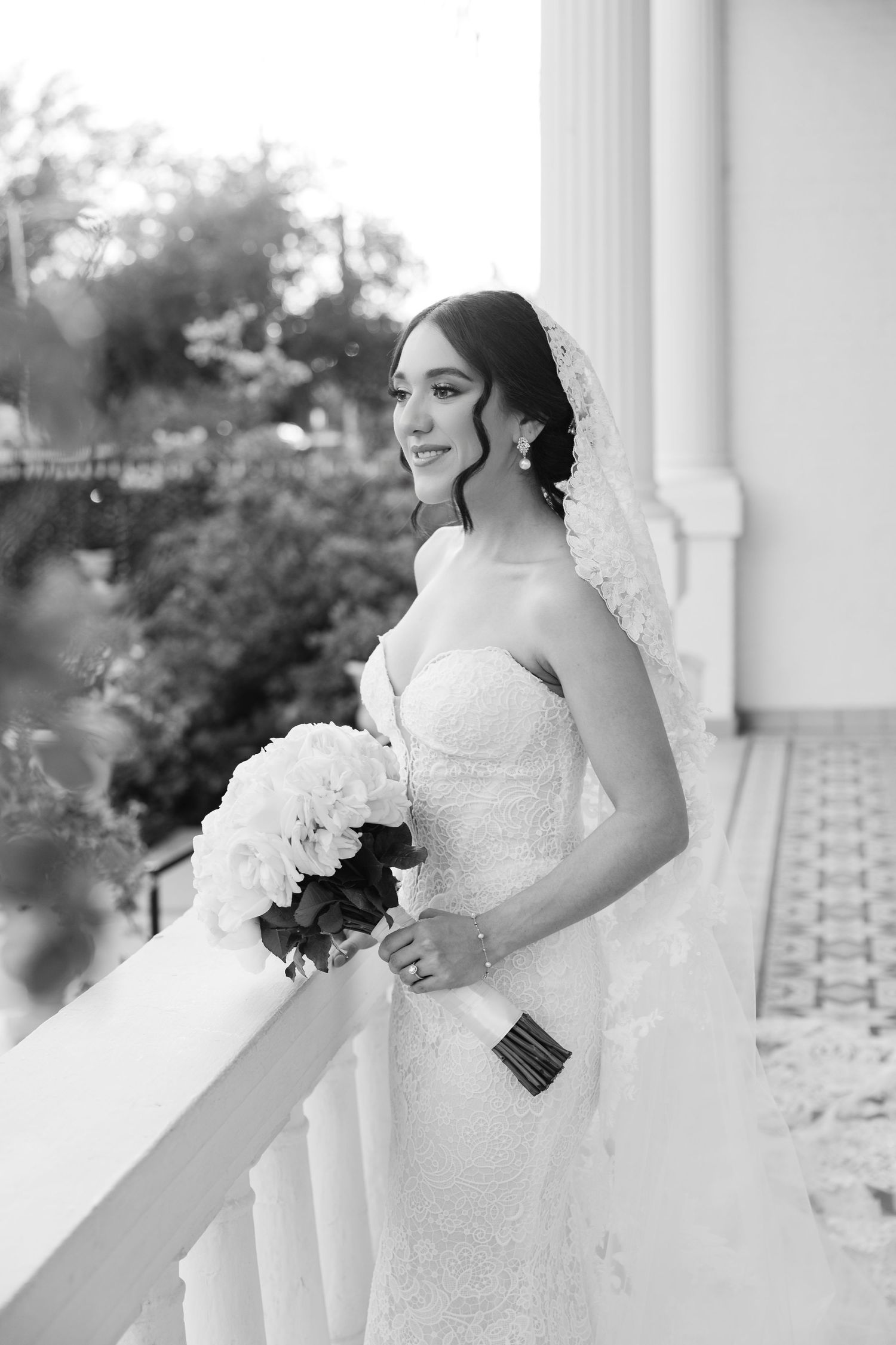Elegant white wedding dress photographed against classic columned architecture.