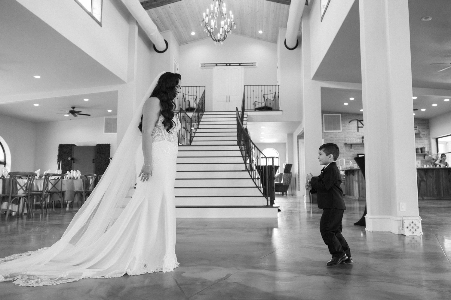 Interior of a bright wedding venue with white columns and elegant staircase.